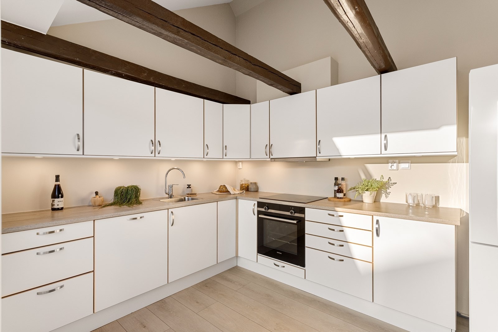 Kjøkkeninnredning fra 2022 med glatte fronter og laminat benkeplate med nedfelt vask. Galleribilde