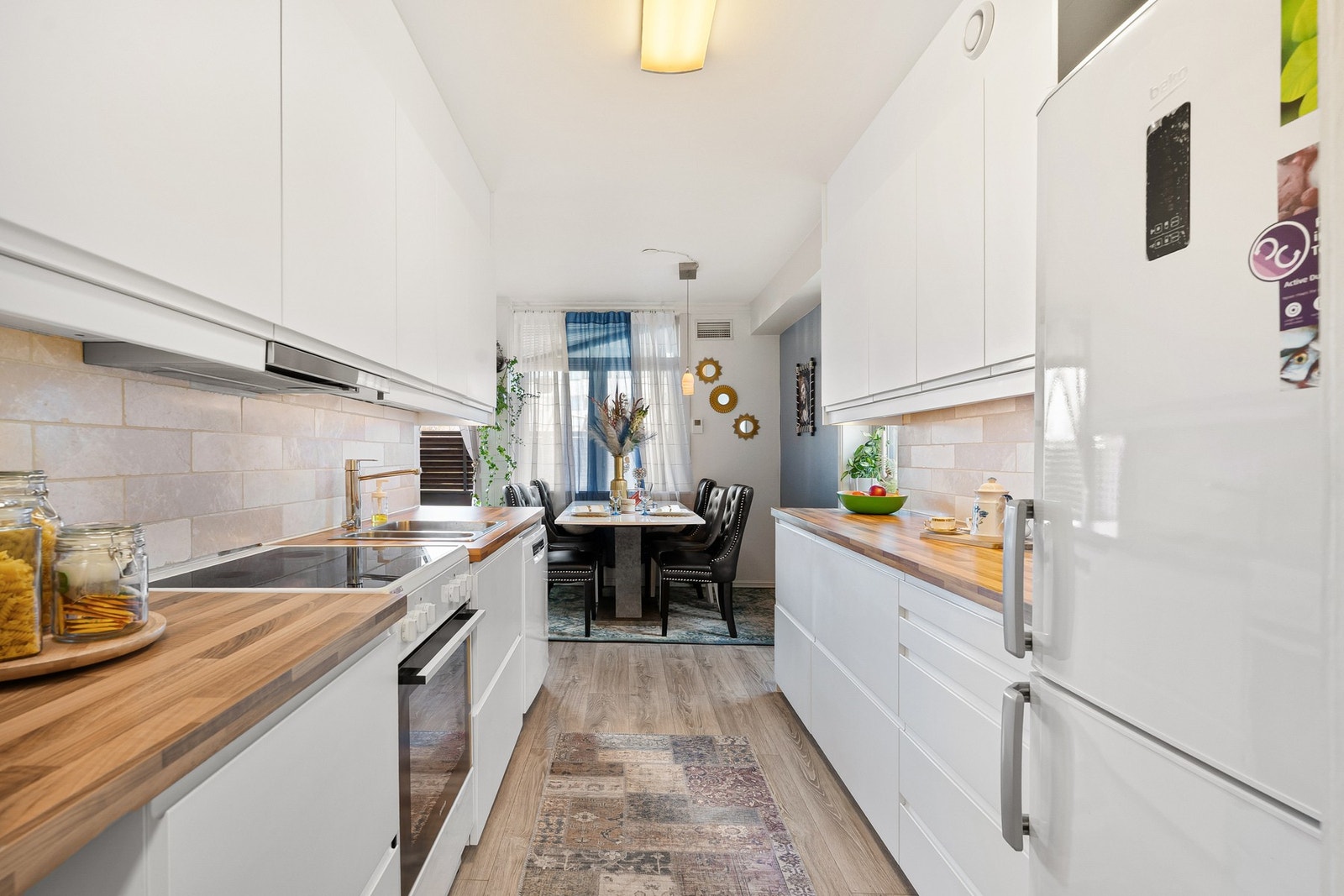 Pent kjøkken med fliser over benkeplate. Galleribilde