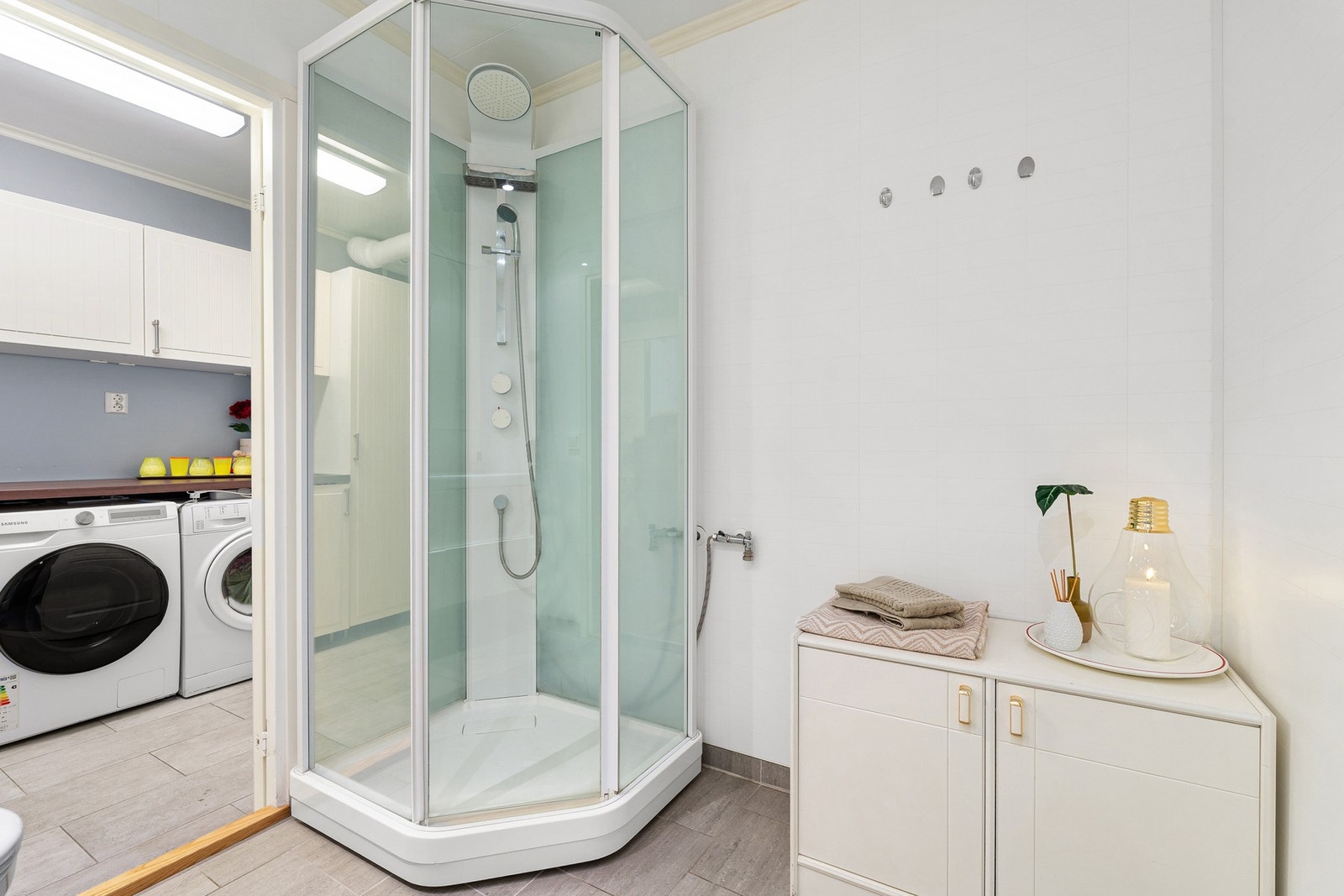 Utstyrt med dusjkabinett, veggmontert toalett og servant i skap. Galleribilde