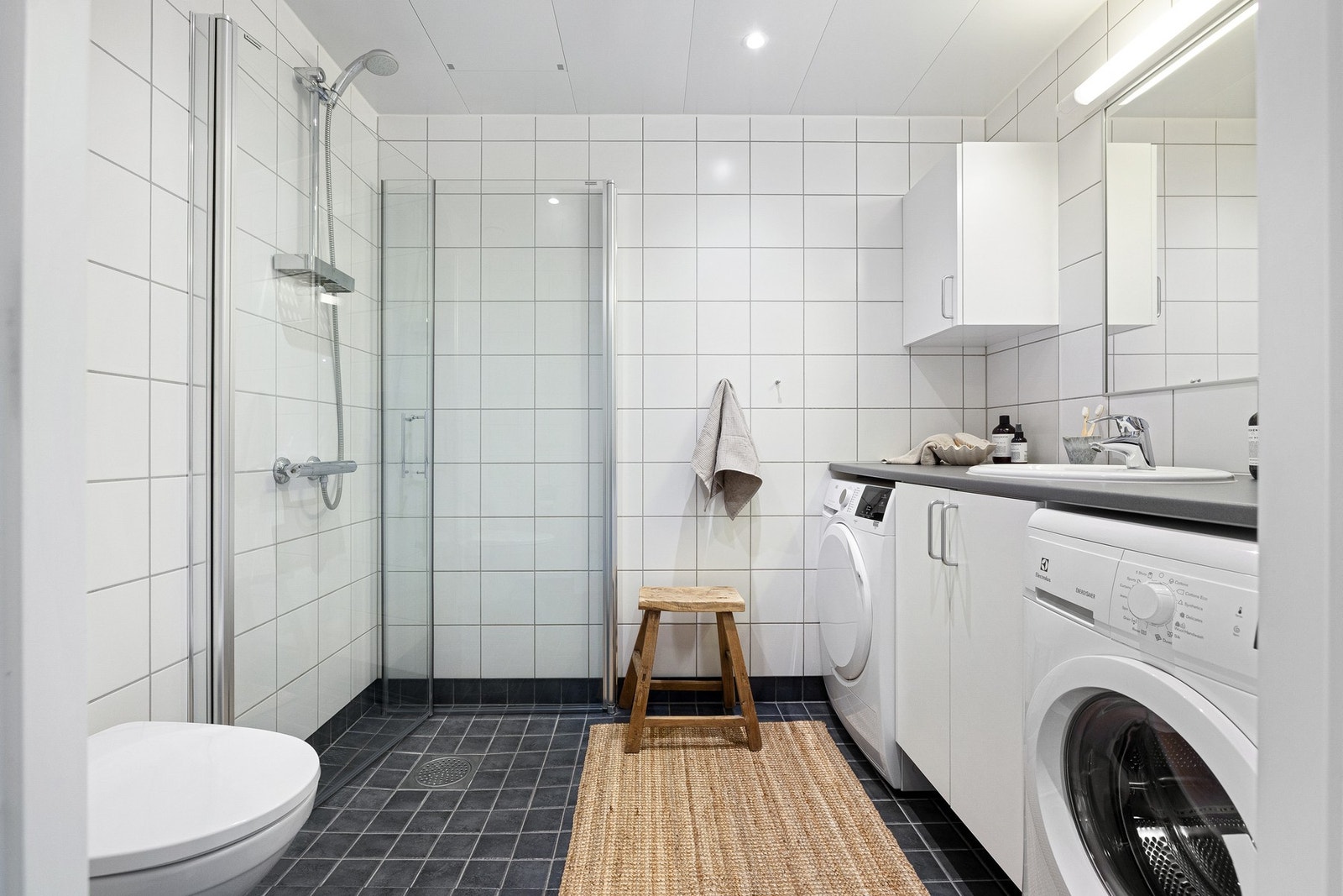 Baderom fra 2013 med flislagte overflater og gulvvarme. Galleribilde