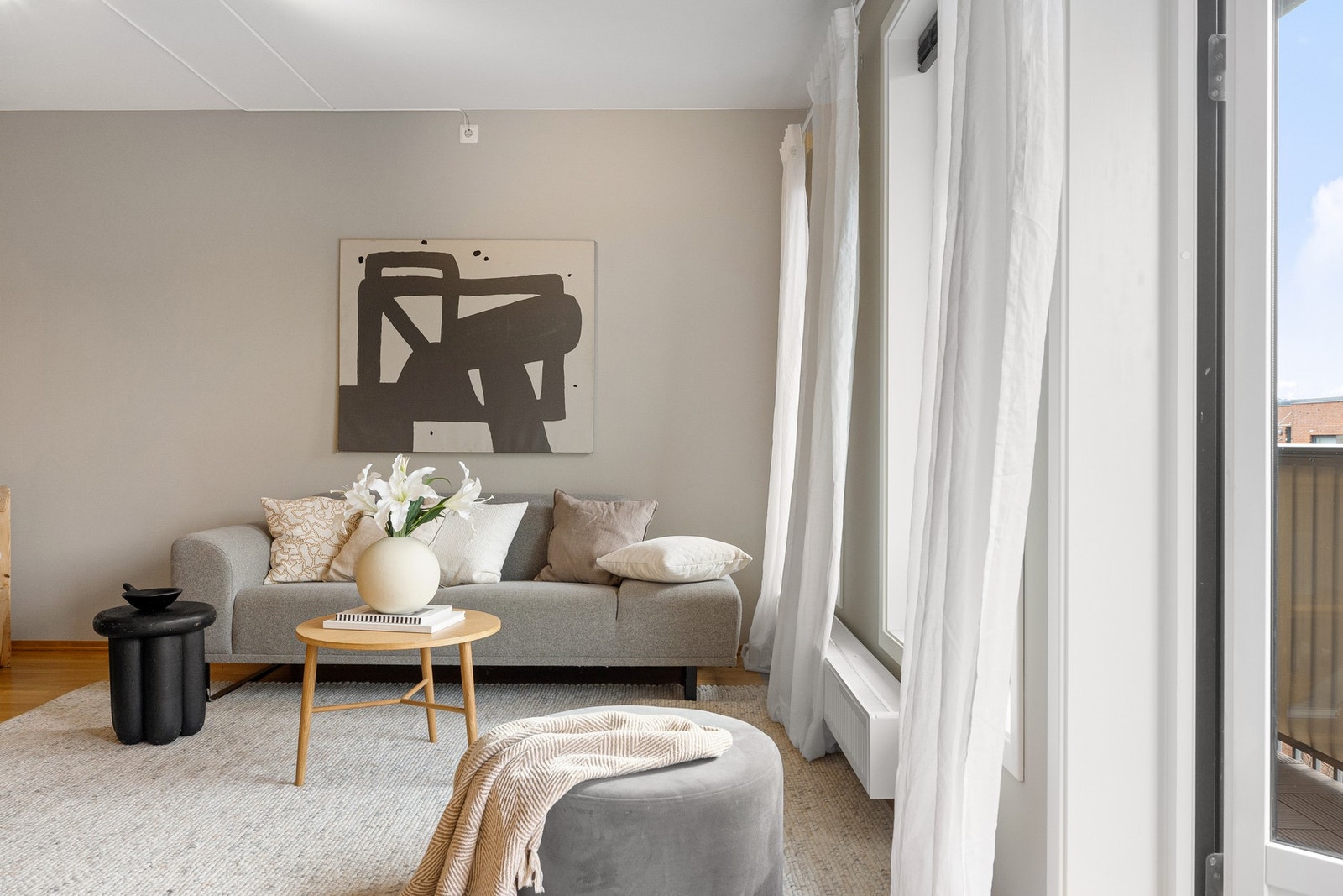 Veggene er malt i en lun og moderne beigetone som harmonerer flott med den gjennomgående parketten, og gir rommet en varm karakter. Galleribilde