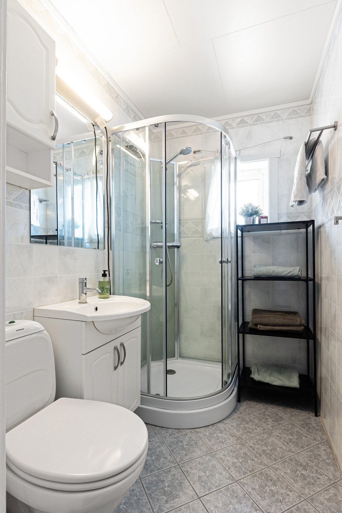 Baderommet er bestående av servant med underskap, dusjkabinett og gulvstående toalett Galleribilde