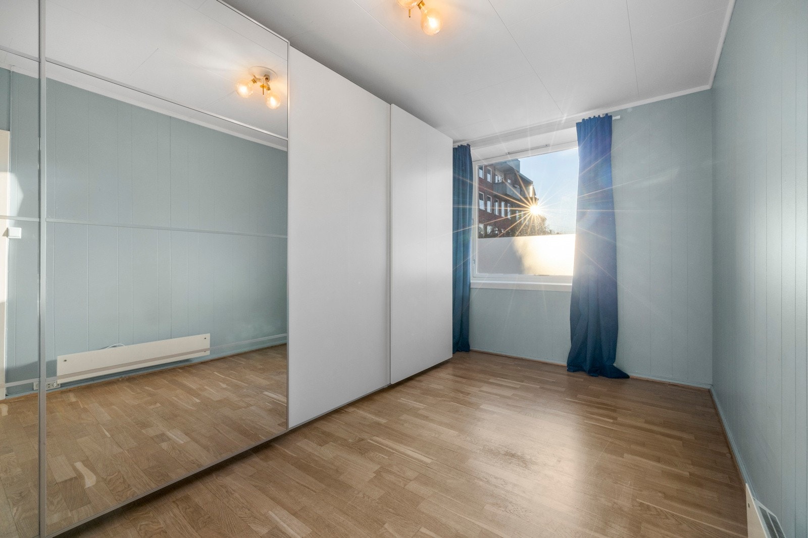 Romslig soverom med god plass til seng og nattbord samt stor vindusflate. Rommet har to doble garderober med speildører, som både gir en følelse av romslighet og sørger for rikelig med oppbevaringsplass. Galleribilde