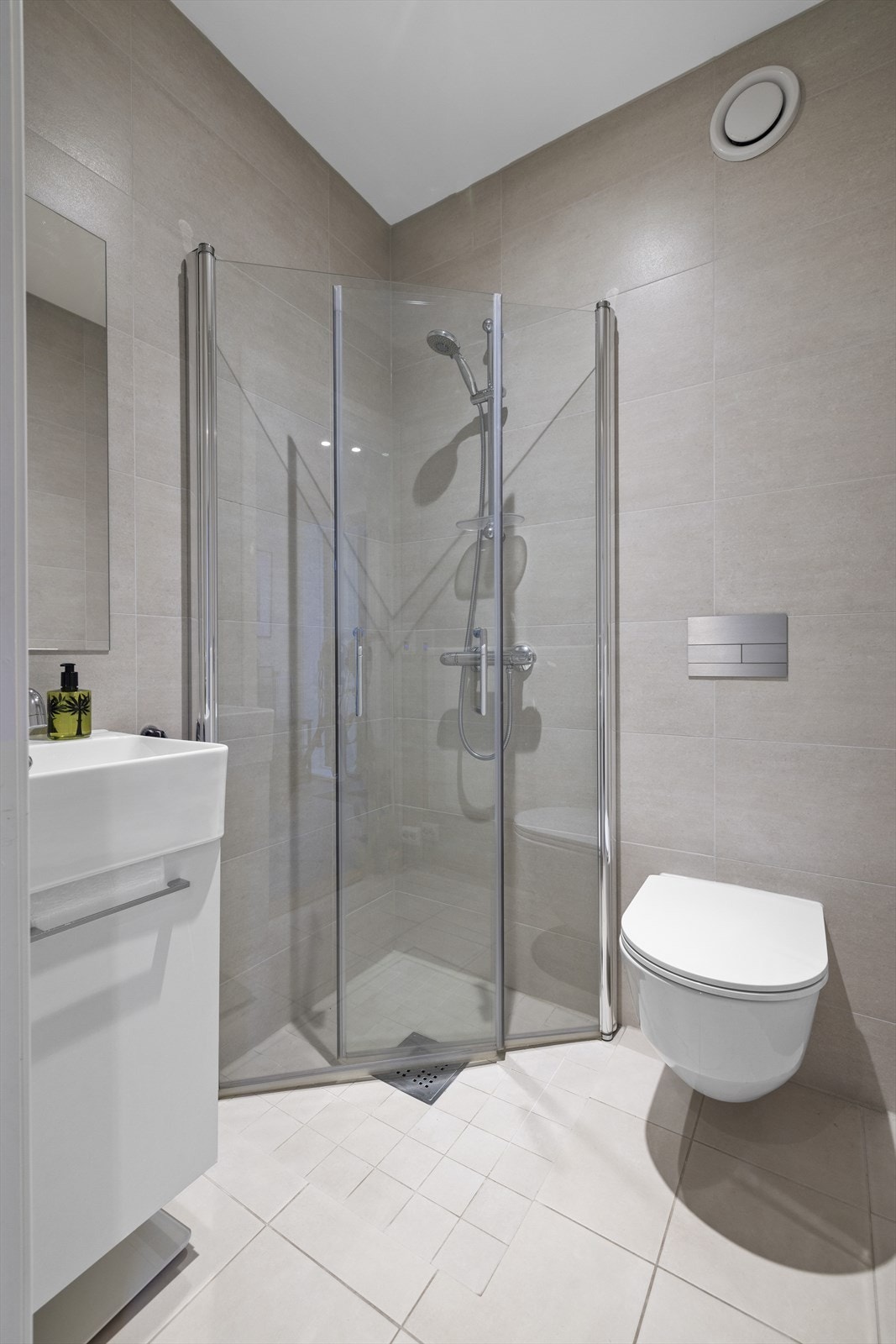 Badet i 1. etasje er helfliset med elektriske varmekabler i gulv og innfelte downlights i himling. Innredet med nedfelt servant, veggmontert toalett og dusjvegger/hjørne. Innbygget sisterne med safteybag Galleribilde