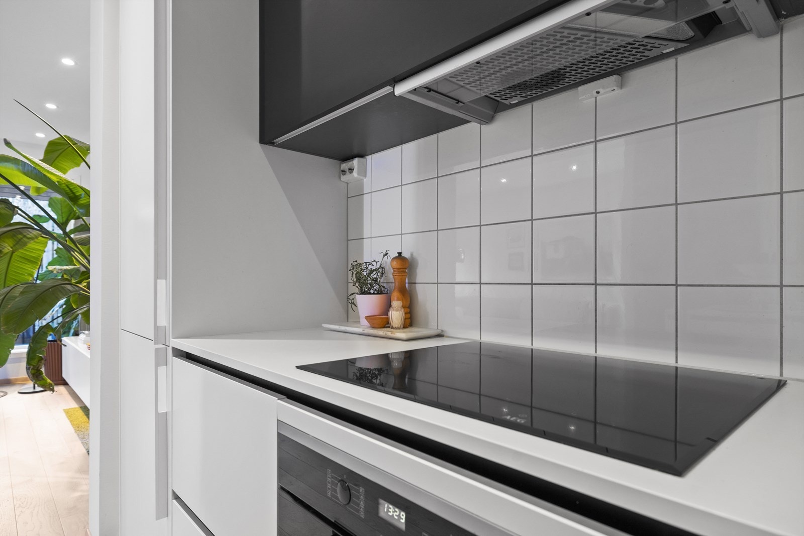 Integrerte hvitevarer inkluderer Míele oppvaskmaskin, kombinert kjøl/frys og stekeovn, nedfelt AEG induksjonstopp, og Temptech vinskap Galleribilde