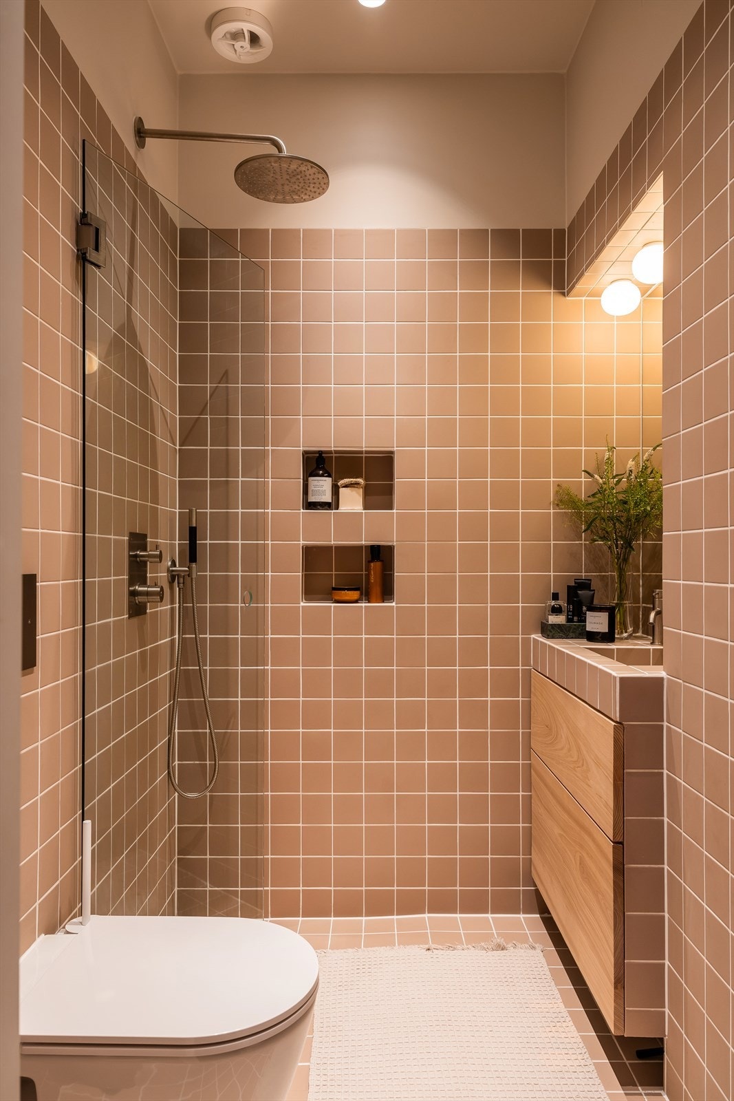 Dusjhjørne med glassdører fra INR og regnfallsdusj fra tapwell i børstet stål. Rommet har varmekabler og elektrisk styrt avtrekksvifte. Galleribilde