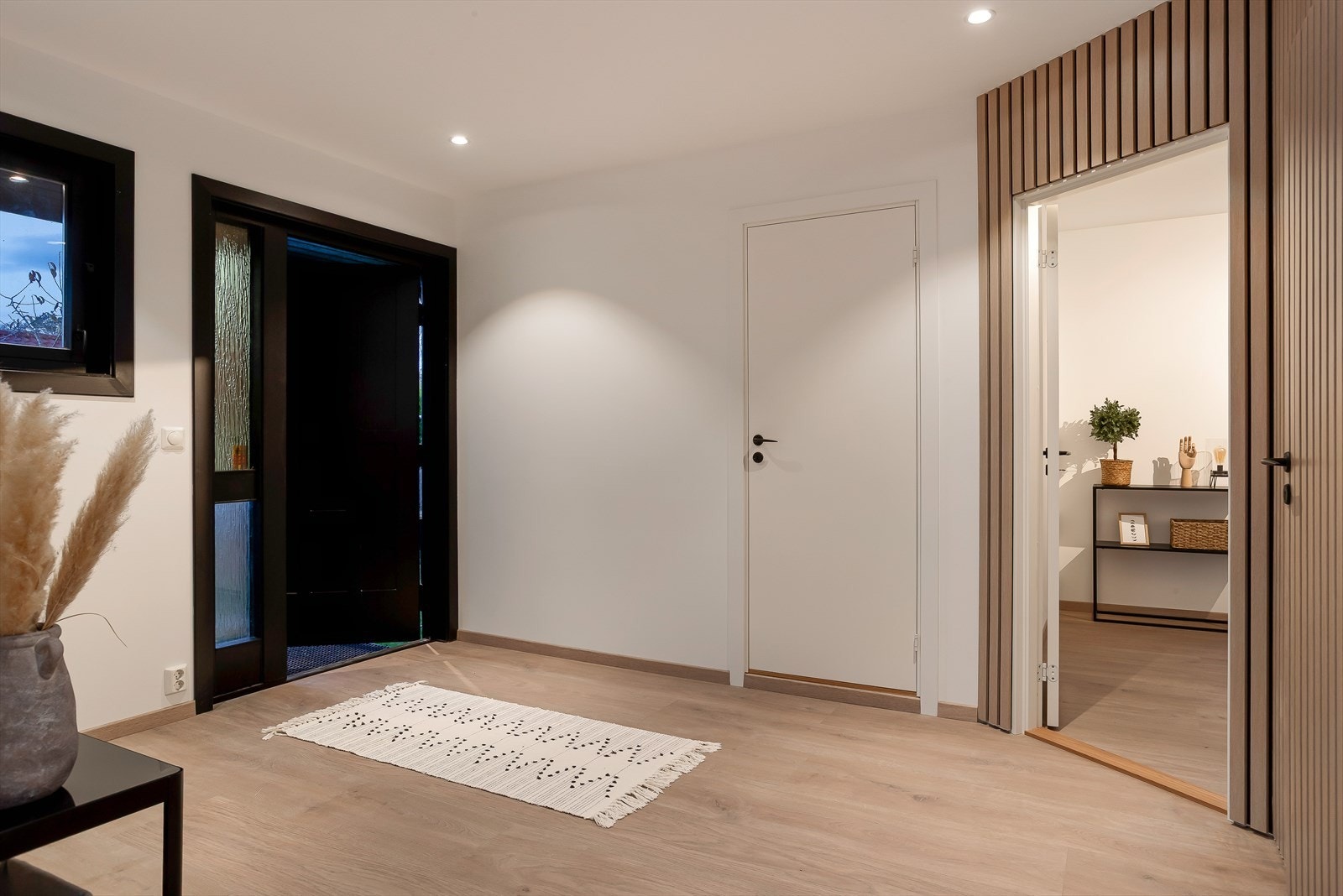 Hallen har plass til oppheng av yttertøy og oppbevaringsmøbel. Herfra er det adkomst til blant annet boligens to bad og fem soverom. Galleribilde