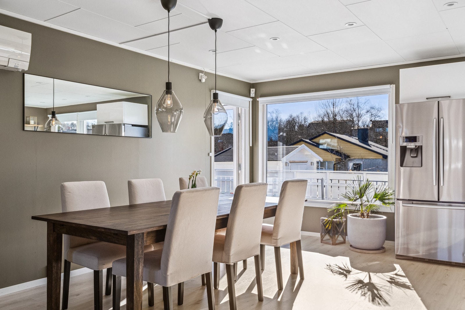 Lys kjøkkenkrok med store vindusflater og utgang til solrik terrasse. Galleribilde