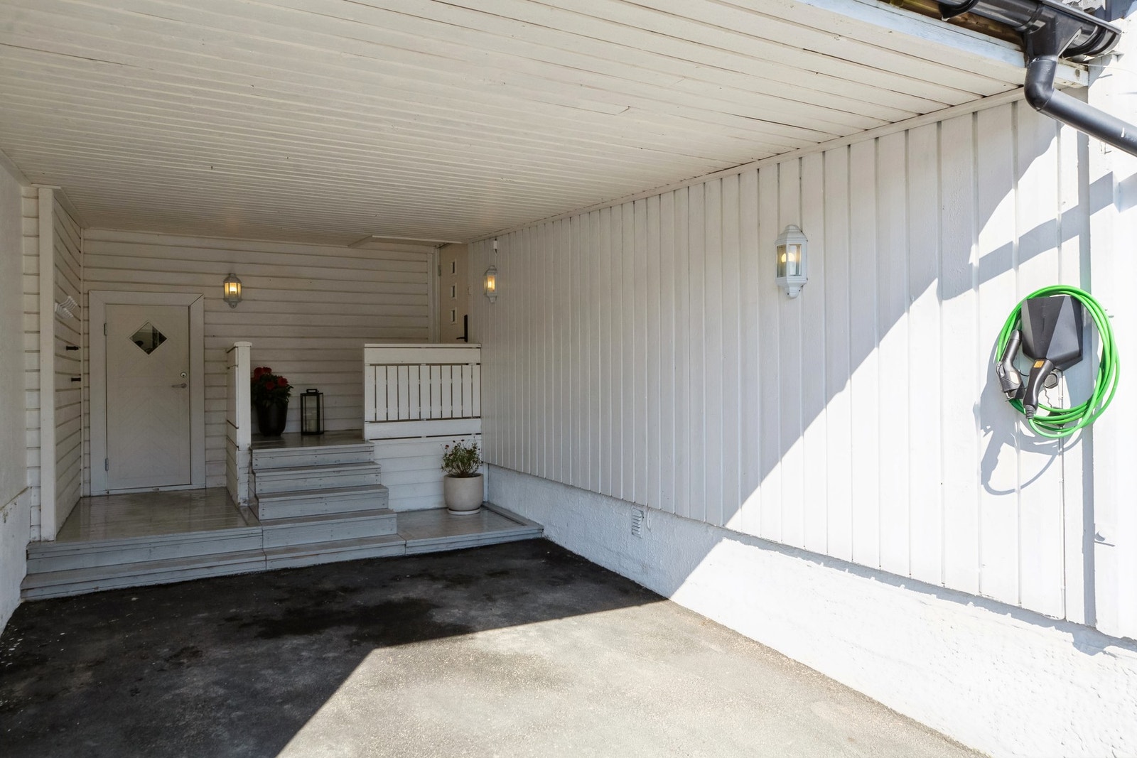 Carport med direkte inngang til boligen og sportsbod med egen utgang til hagen. Det er montert elbil-lader i carporten. Galleribilde