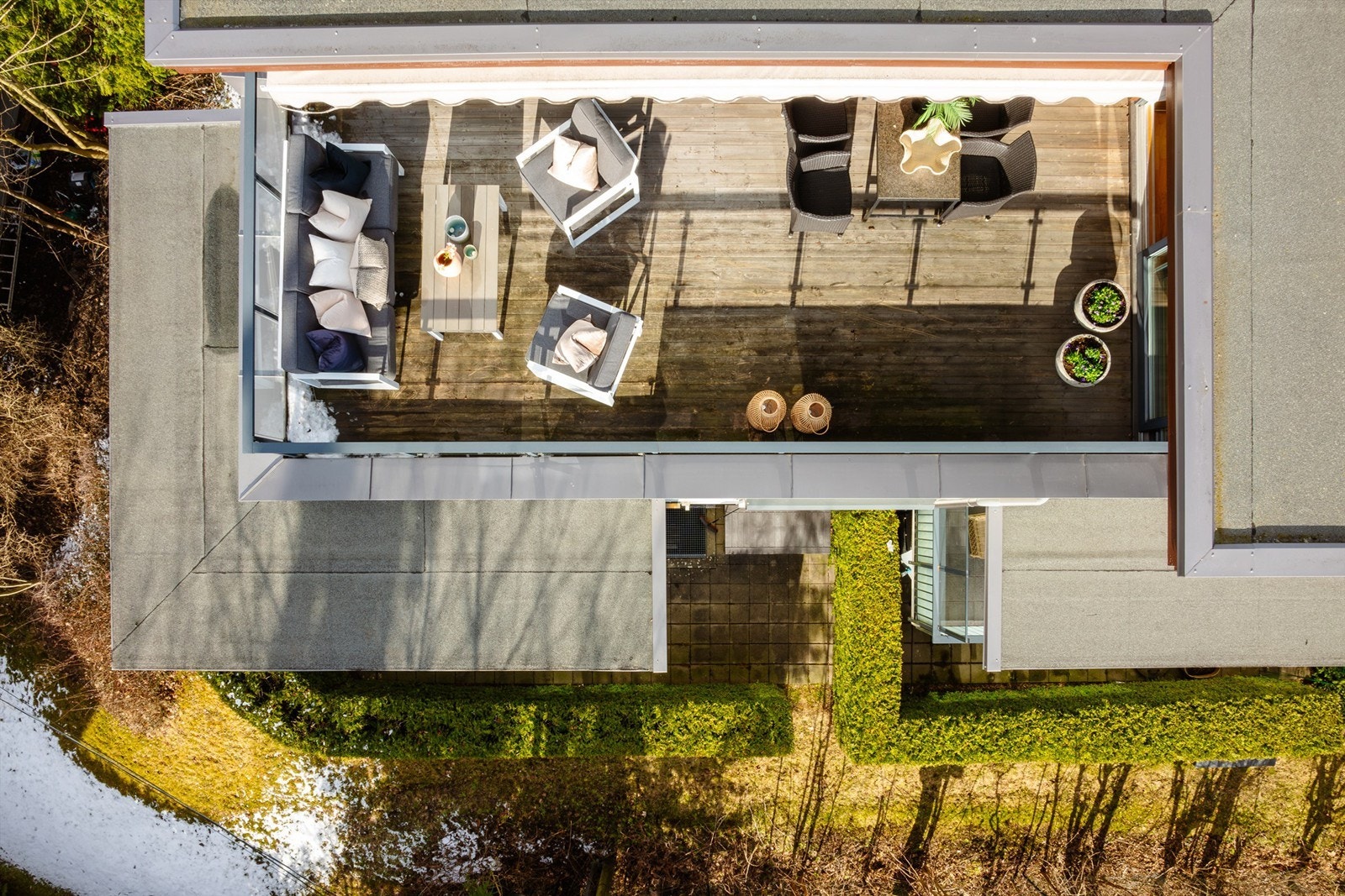 Terrassen har markise og er belagt med terrassebord og har rekkverk av glass. Galleribilde