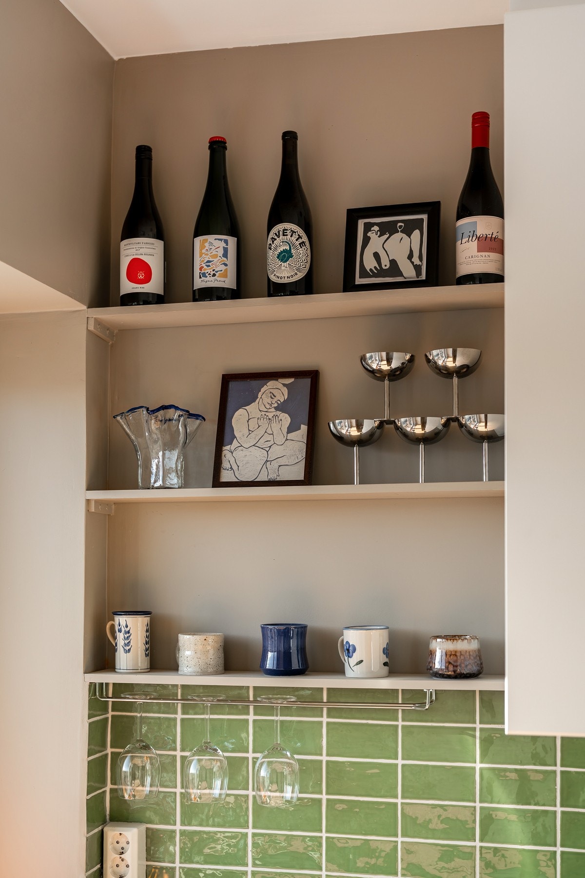 Kjøkkenet er malt i en lun farge med herlige grønne fliser mellom benkeplate og overskap Galleribilde