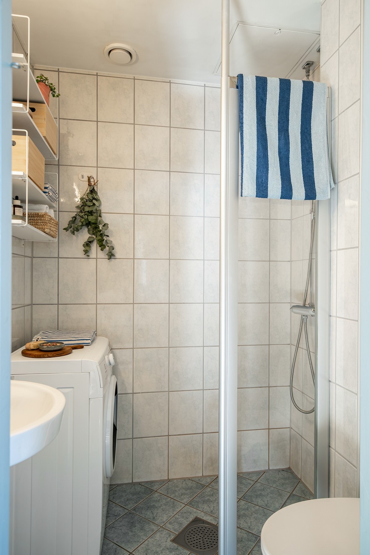 Baderom fra 2005 med flislagte vegg- og gulvflater. Opplegg og plass til vaskemaskin Galleribilde