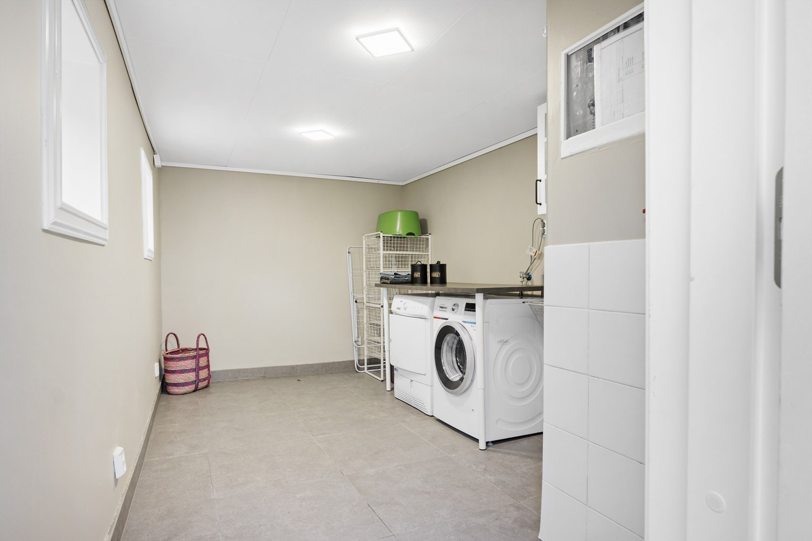 Vaskerom med flislagt gulv, utstyrt med opplegg for vaskemaskin, fordelerskap til rørsystemet og varmtvannsbereder. Tak og veggflater oppgradert i 2022, med ny isolasjon og gipsplater Galleribilde