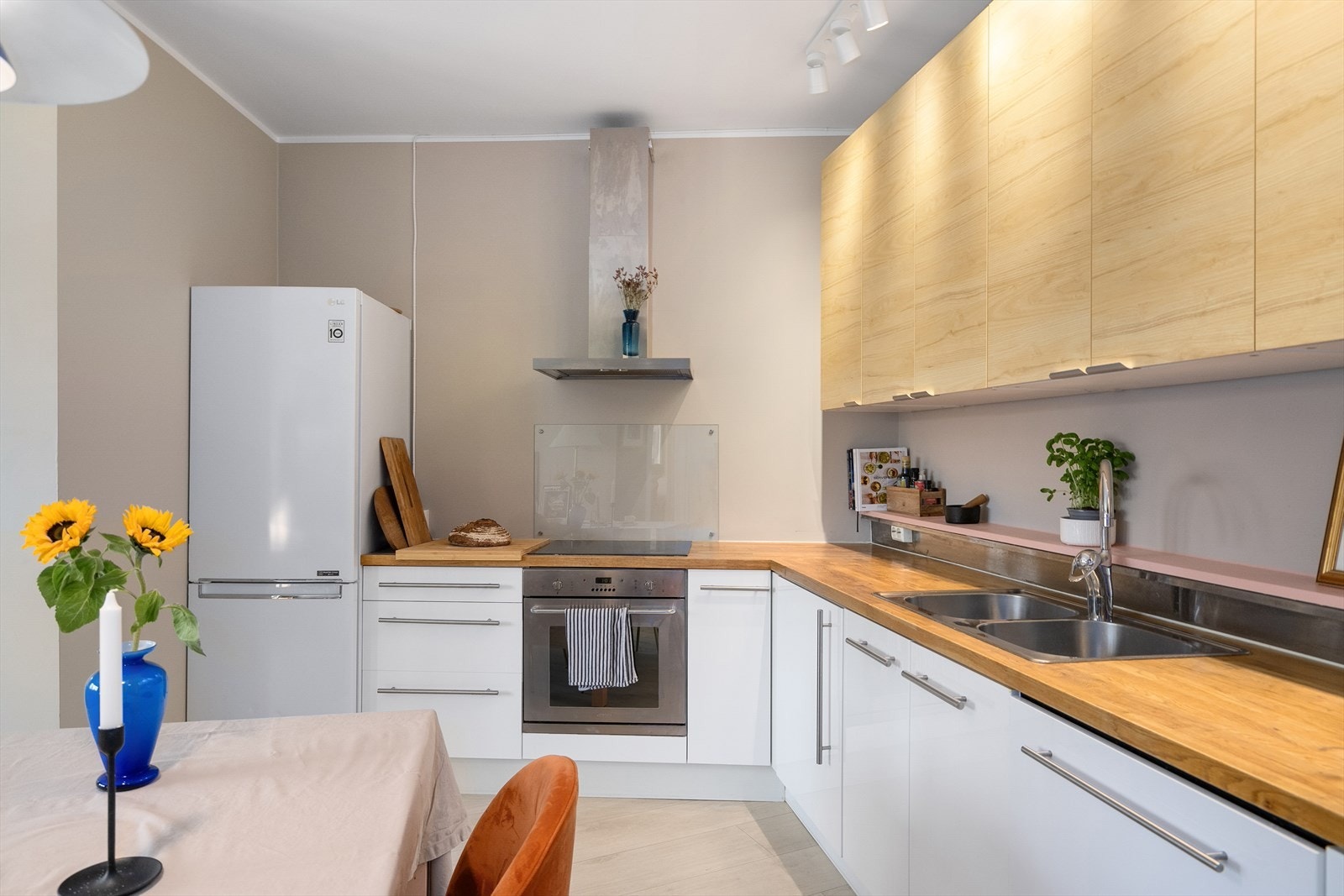 Kjøkkeninnredning med glatte fronter og heltre benkeplate Galleribilde