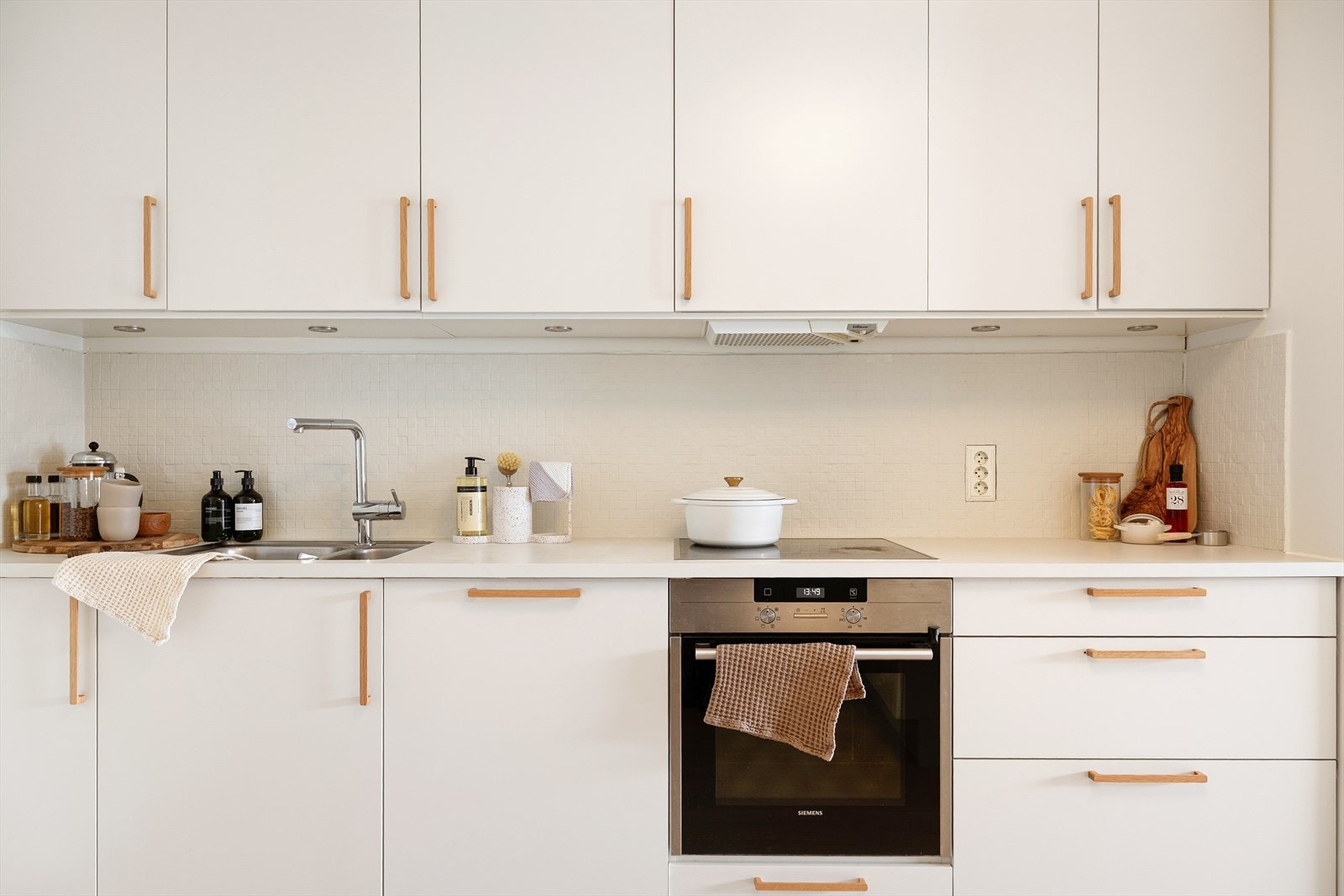 Malt benkeplate og backsplash. Håndtakene ble byttet i 2025 og gir et moderne uttrykk Galleribilde