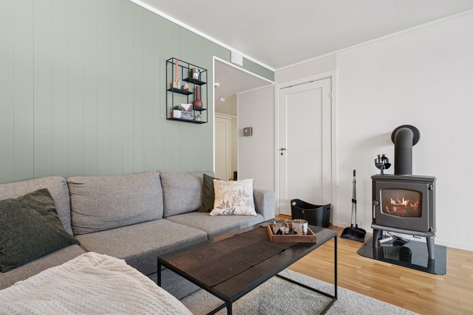 Videre er det adkomst til stuen, som er i åpen løsning med kjøkken i tillegg til ildsted for kjølige dager. Galleribilde