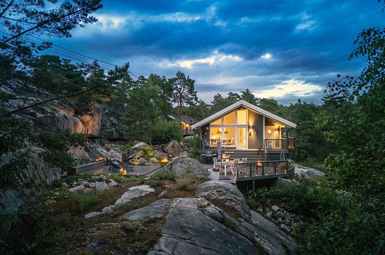 På en høyde omkranset av furutrær hviler hytta vakkert i den ville naturen, med båtplass og strand i kort gangavstand Galleribilde