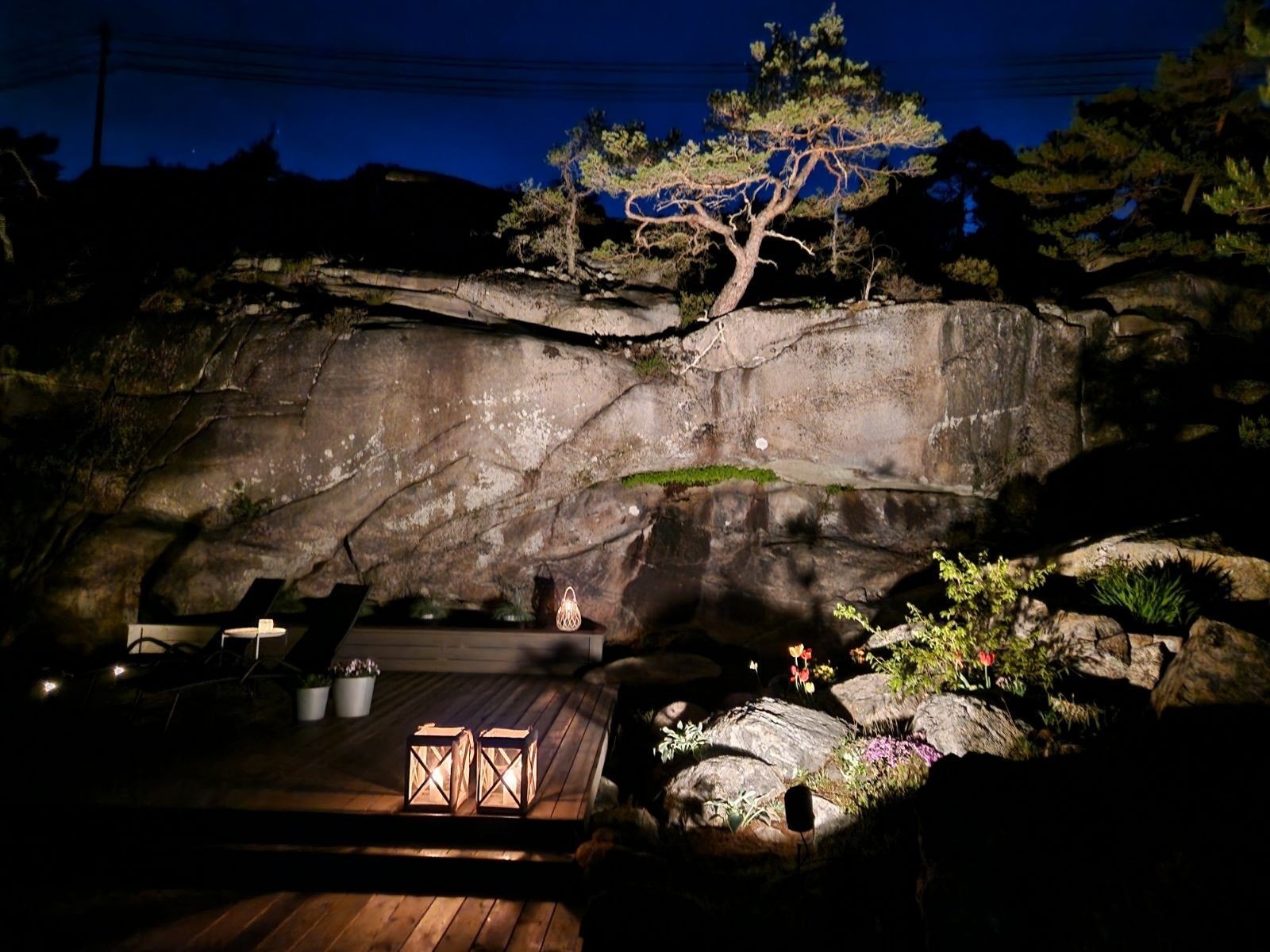 Det er montert Philips Hue spot som lyser mot fjellveggen, og nedfelte LED-lys rundt terrassen og gangveien rundt hytten Galleribilde