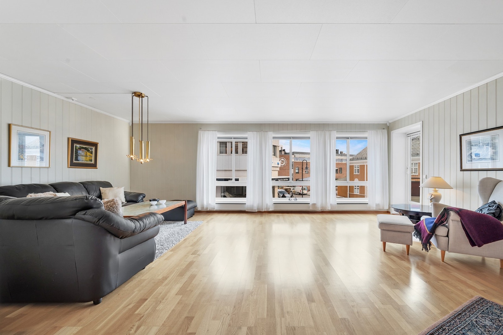 Romslig stue med parkett på gulv. Galleribilde