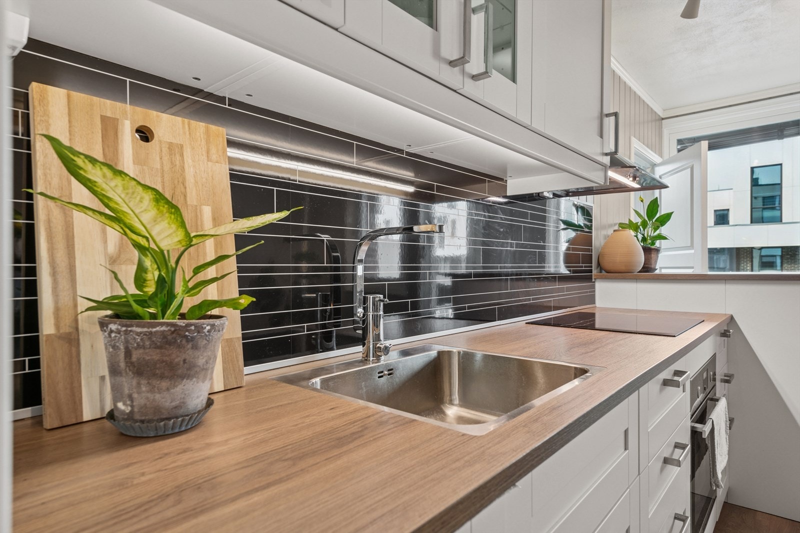 På veggen over benkeplaten er det dekorative laminatplater, og under overskapene er det belysning. Galleribilde