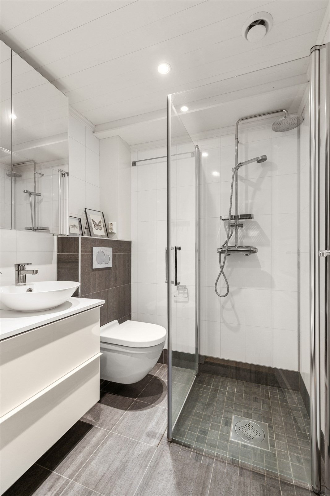 Dusjhjørnet har innfellbare glassdører og veggmontert dusjsett med både hånd- og regndusj. Galleribilde