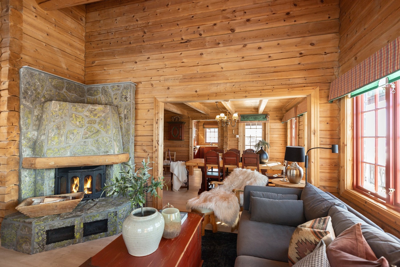 Innvendig byr hytta på gulv av heltre, skifer og fliser. Vegger i laftet tømmer, himlinger med bjelker og rundhøvlede åser Galleribilde
