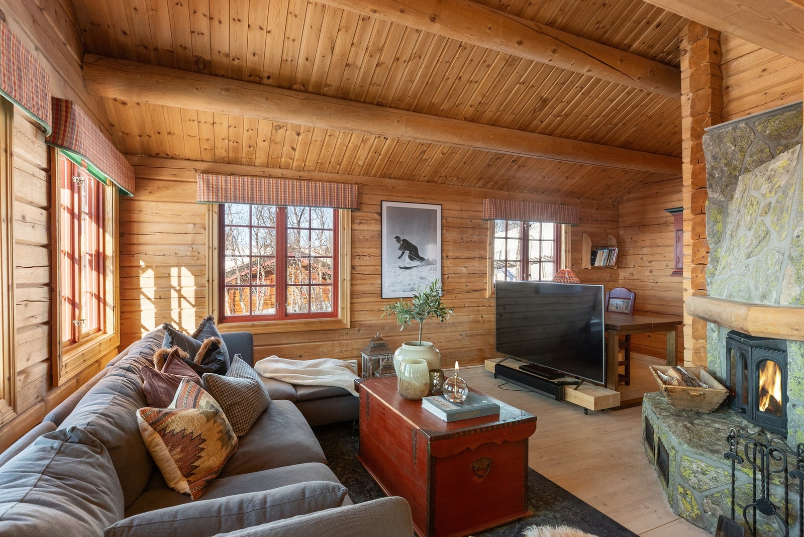 Denne delen av stuen har svært god takhøyde og flott peis forblendet med naturstein Galleribilde