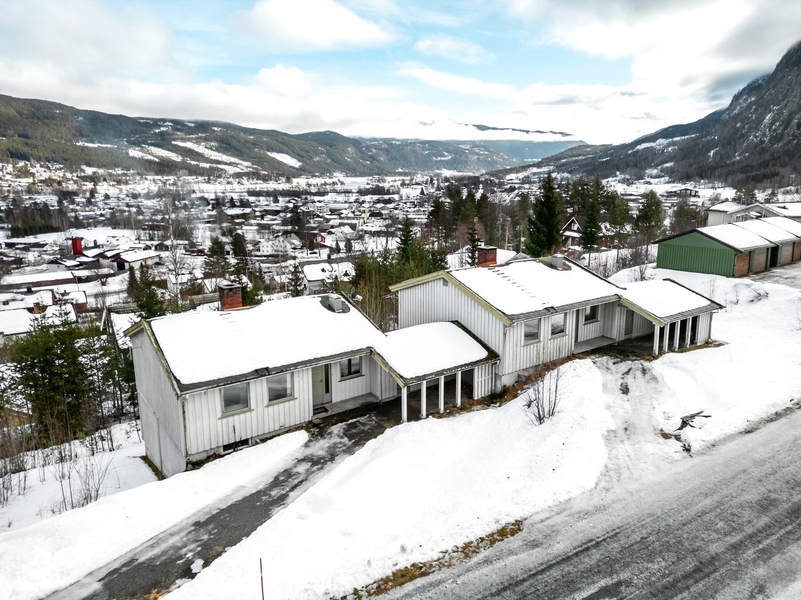 Begge tomannsboligene har to etajer. Flere parkeringsmuligheter i carport og utenfor boligene. Galleribilde