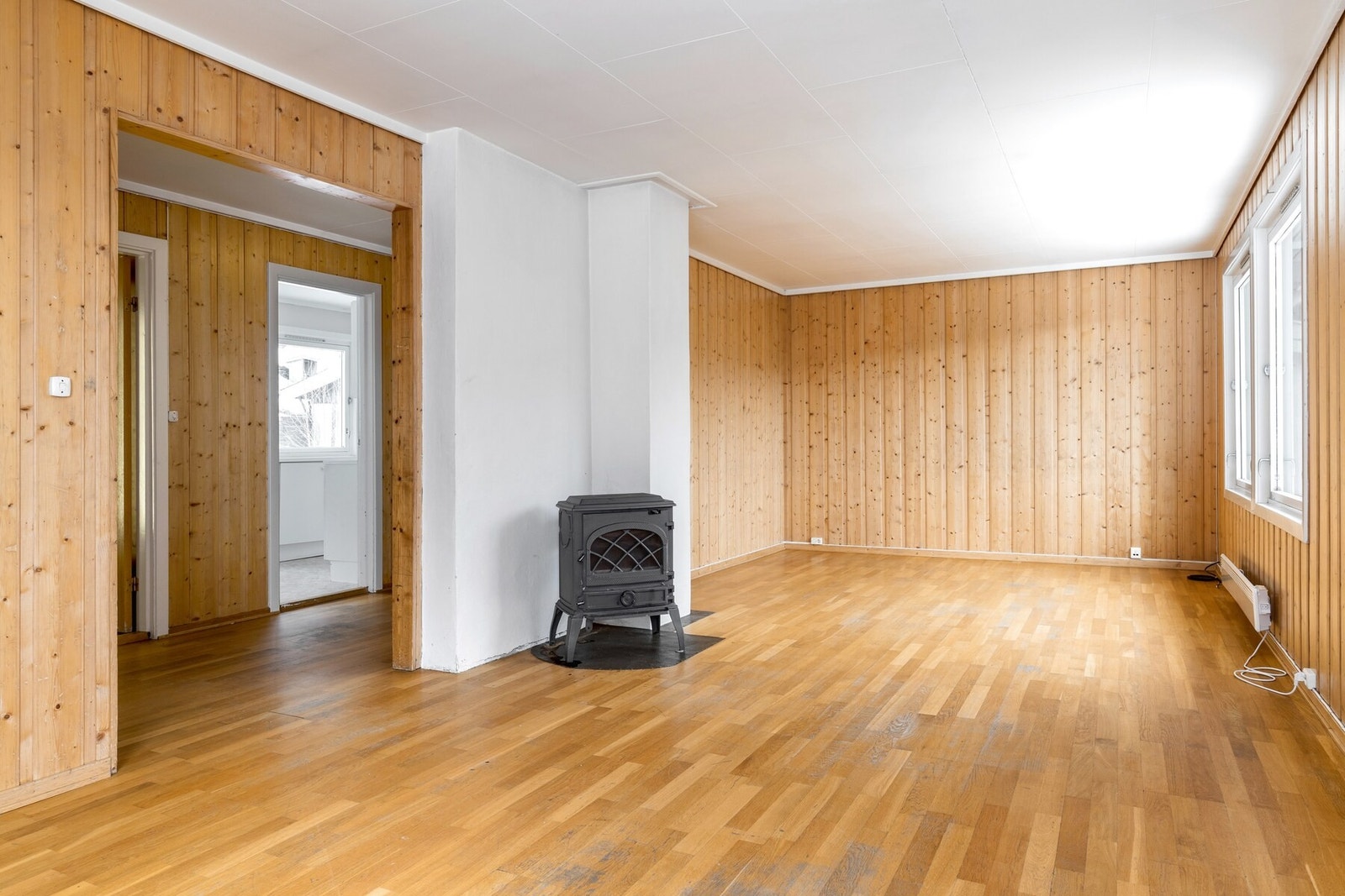 Videre kommer du til en stue med peisovn og store vinduer, med utsikt mot sentrum. Galleribilde