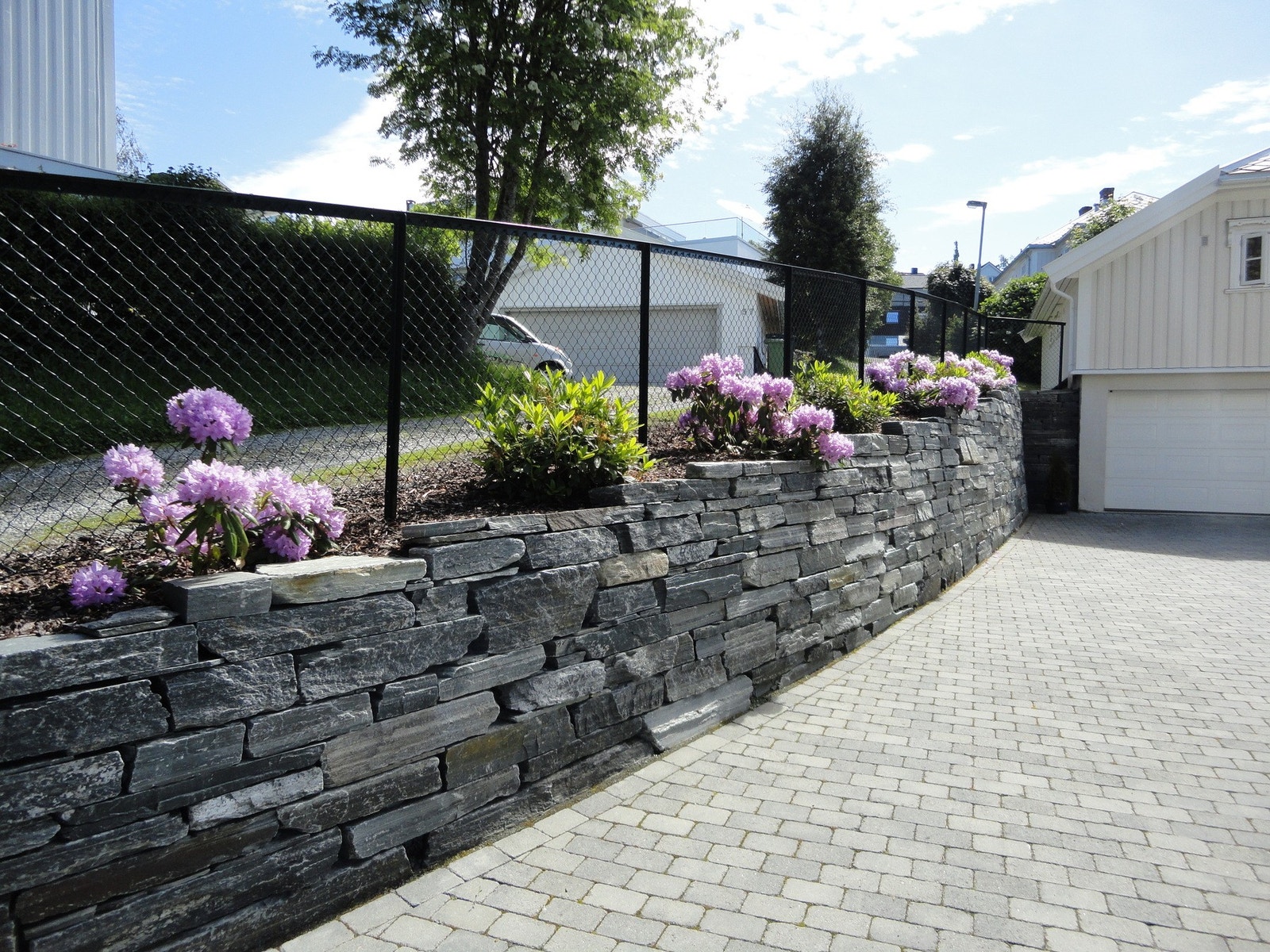 Eiendommen fremstår som svært gjennomført med både belegningsstein, murer og flotte bedd. Galleribilde