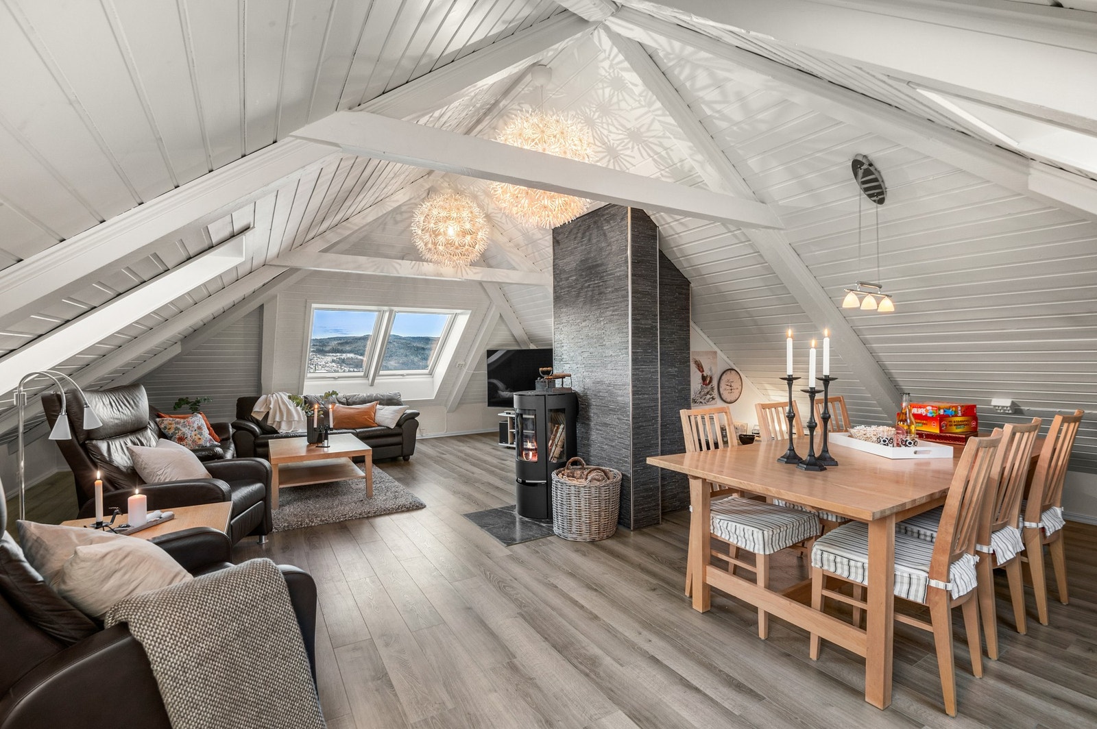 Loftstuen byr på en koselig atmosfære, der de synlige takbjelkene og skråtaket skaper en hjemmekoselig følelse. Galleribilde