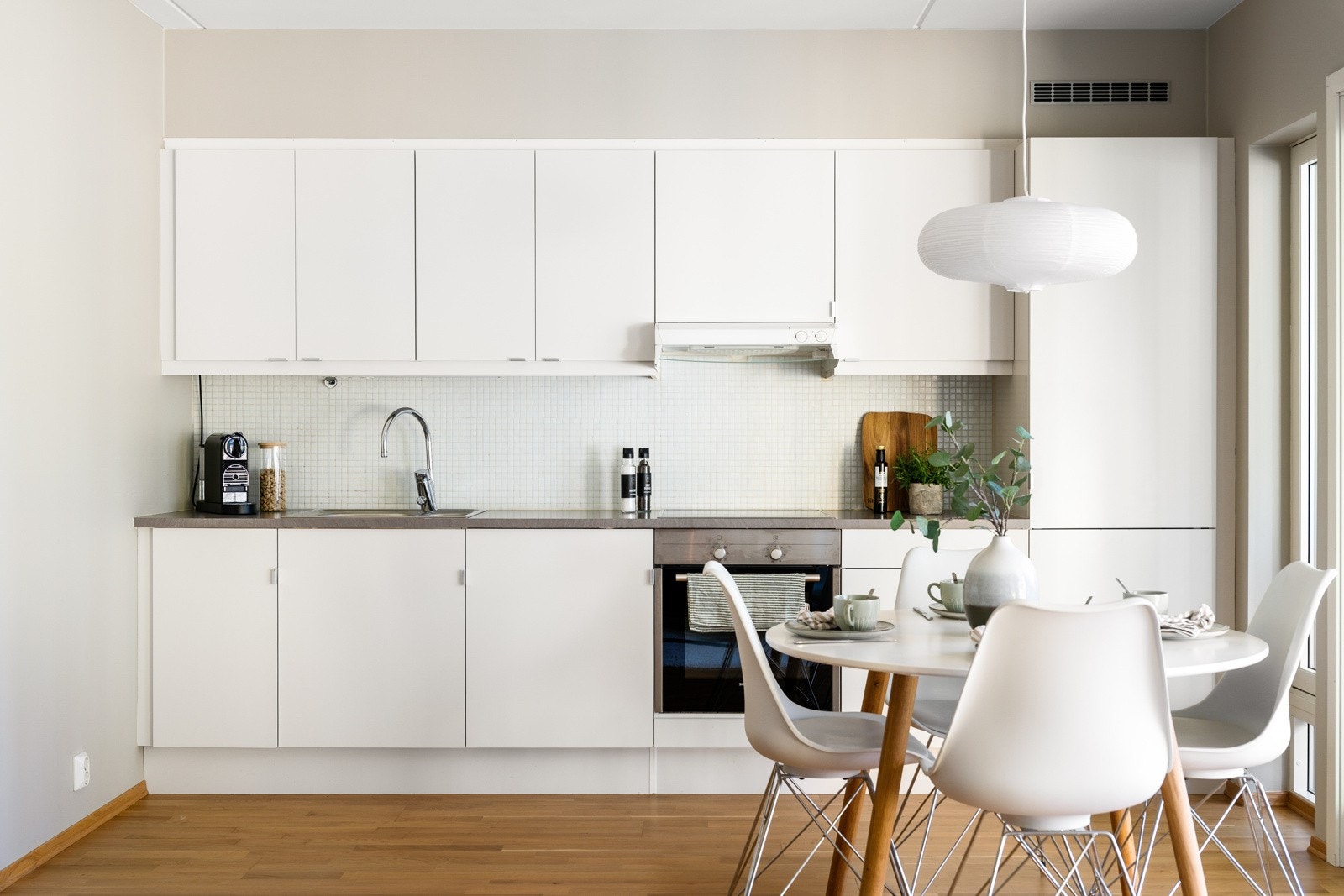 Kjøkkeninnredningen er av tidløs utførelse med hvite og slette fronter, samt integrerte hvitevarer. Galleribilde