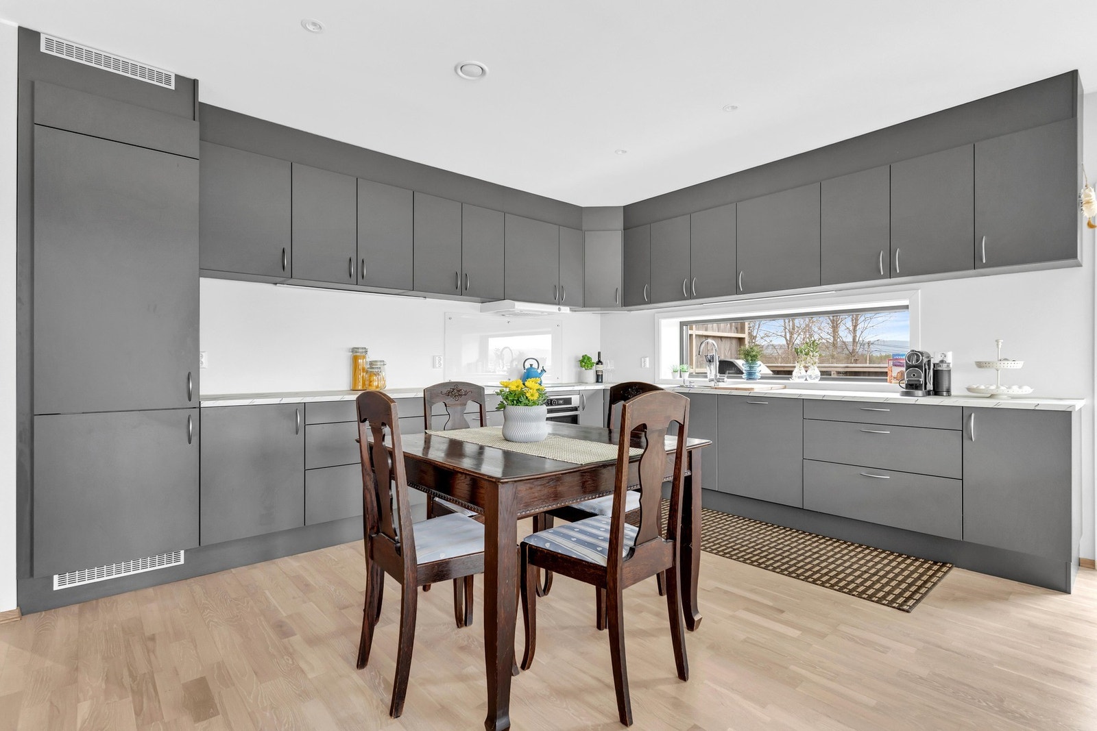 Mellom kjøkkenbenk og overskap er det satt inn et avlangt vindu som sørger for godt med naturlig lysinnslipp. Galleribilde