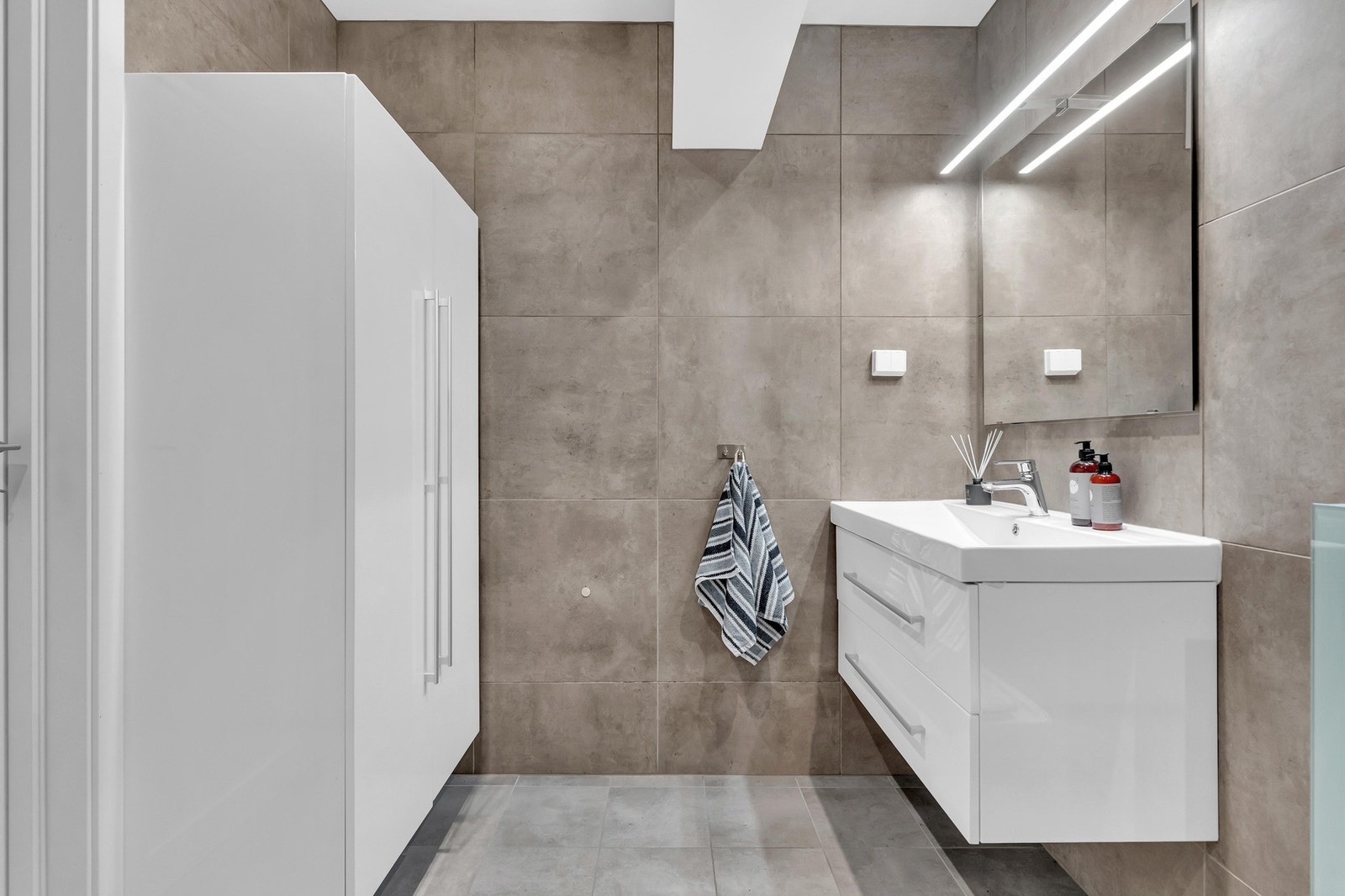 På badet er det et dobbelt høyskap med god plass til lagring av ulike av toalettsaker og håndklær. Galleribilde