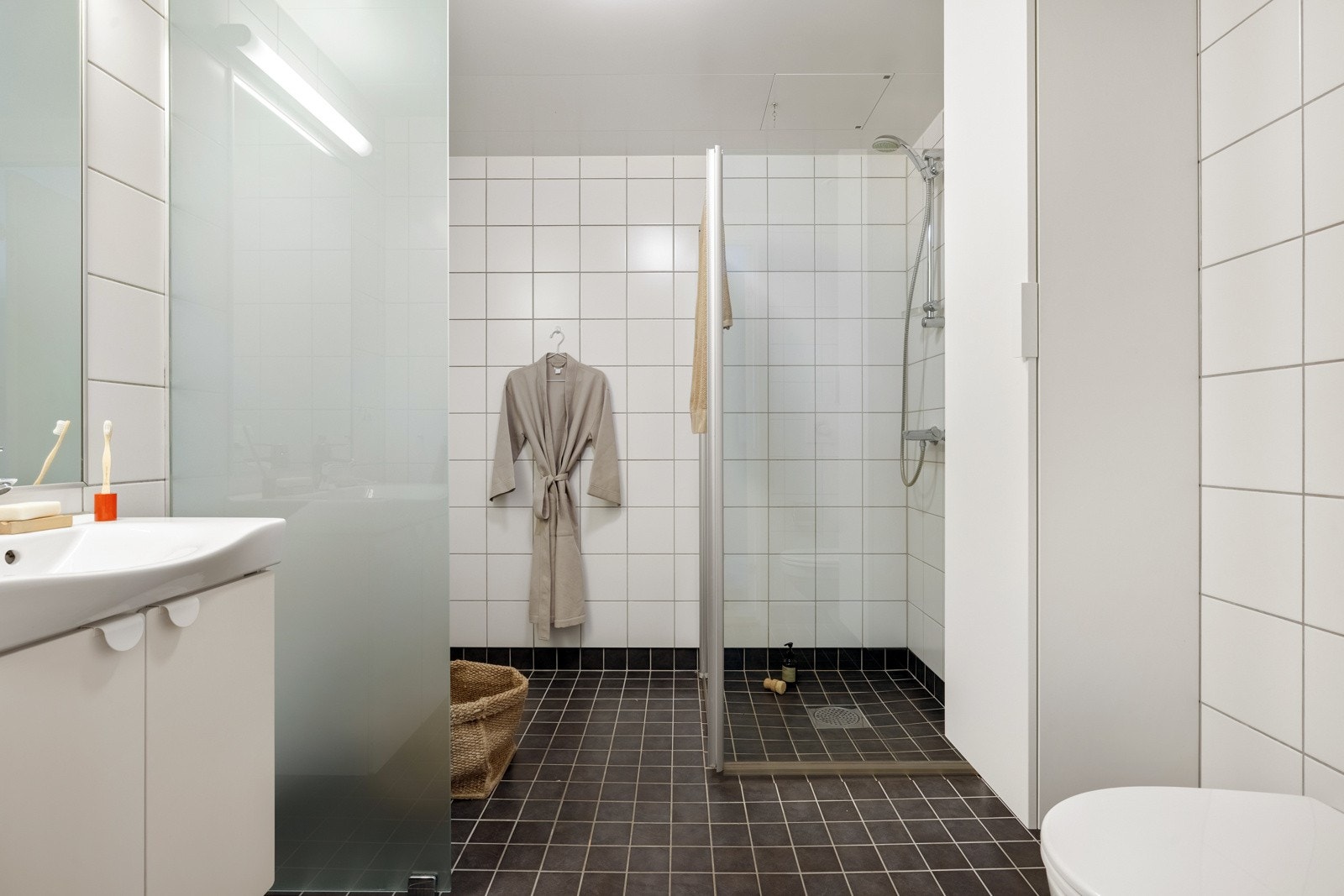 Det er god plass til oppbevaring i baderomsinnredningen og rommet har et moderne uttrykk. Galleribilde
