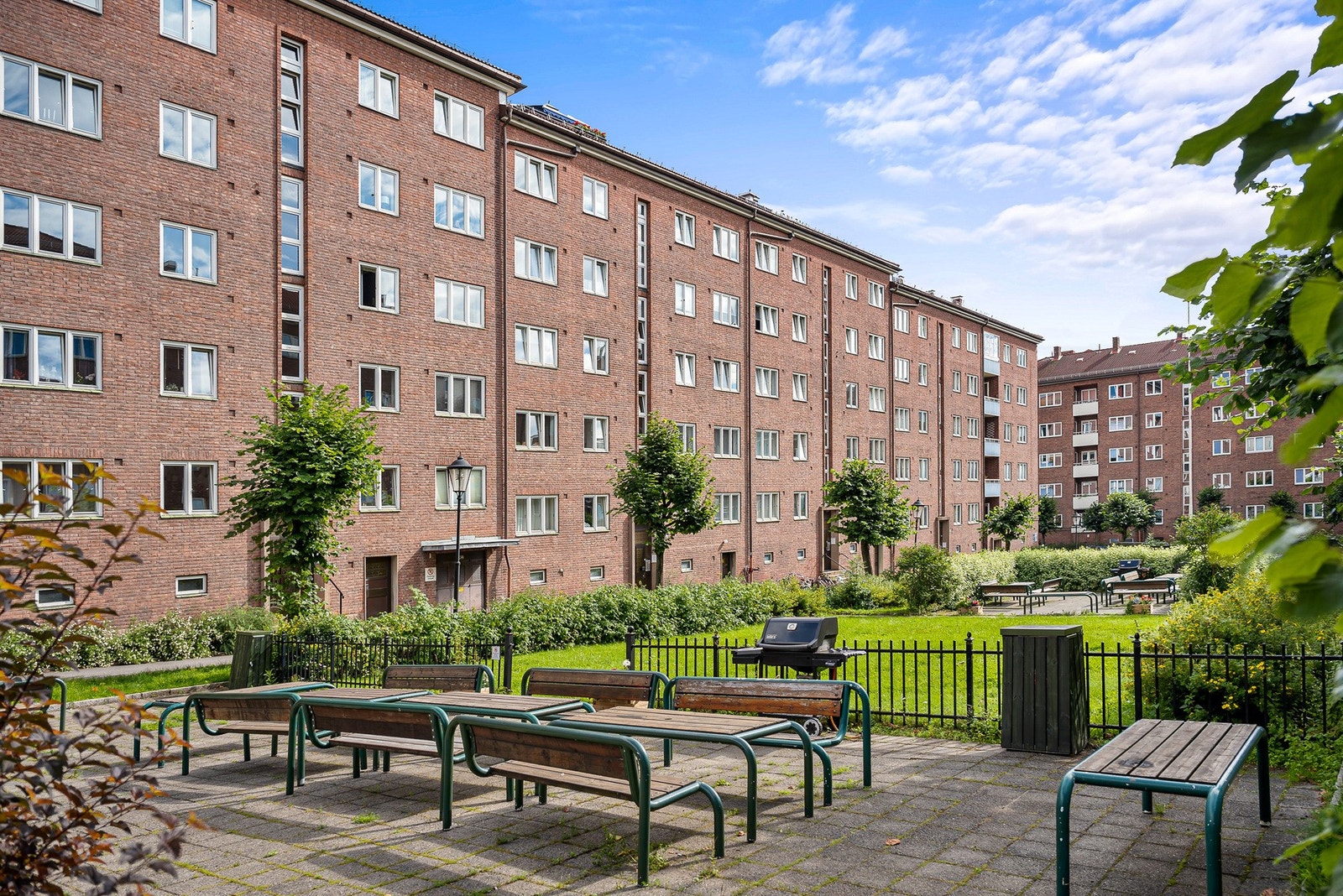 Bakgården byr på grøntområde og flere sitteplasser, et perfekt sted for avslapning eller sosiale sammenkomster. Galleribilde