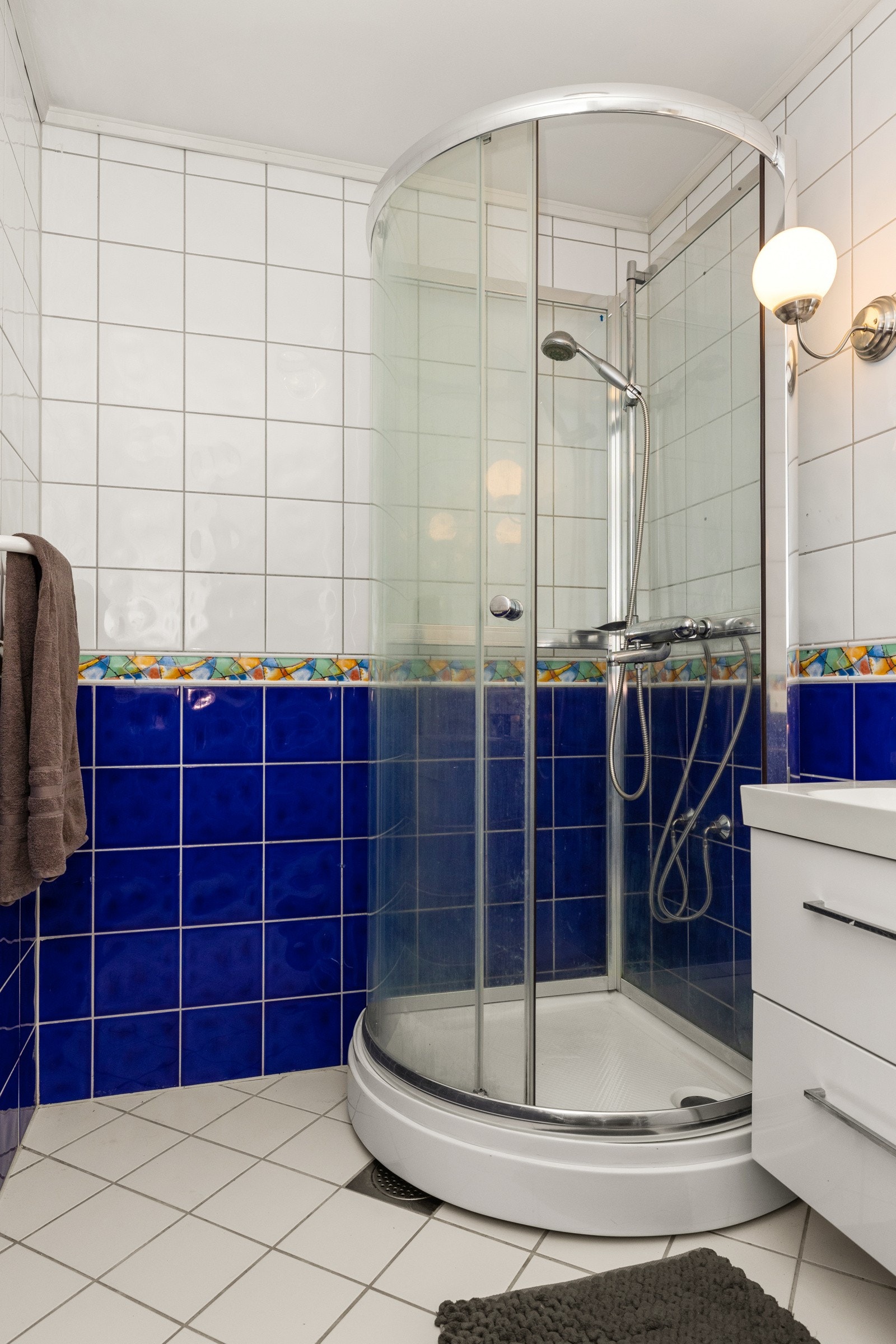 Baderommet er utstyrt med innredning, speil og dusj Galleribilde