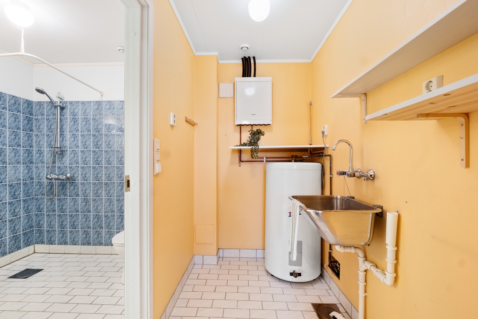 Praktisk bad med flislagte overflater og varmekabler i gulvet. Kombinert med vaskerom for ekstra funksjonalitet. Galleribilde