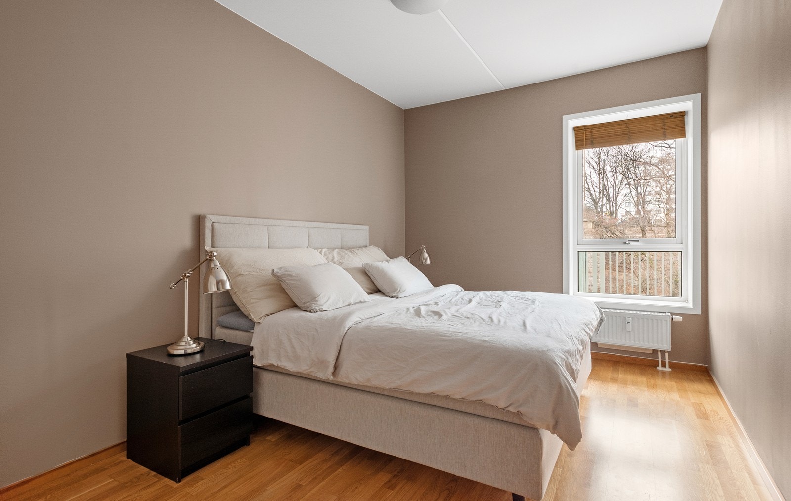 Romslig soverom malt i en lun og dempet tone. Rommet er utstyrt med radiator og garderobeskap Galleribilde