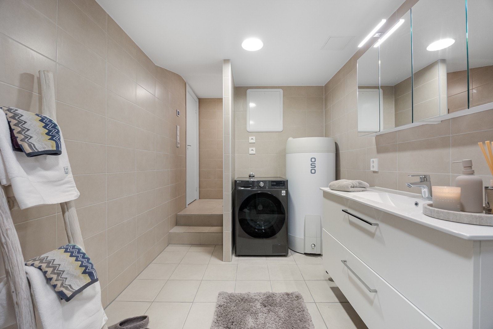 Badet er helfliset med keramiske fliser og har tilkobling for vaskemaskin. Det er også lagt inn rør-i-rør. Mulig å montere skyvedør foran vaskemaskin og varmtvannstank. Galleribilde