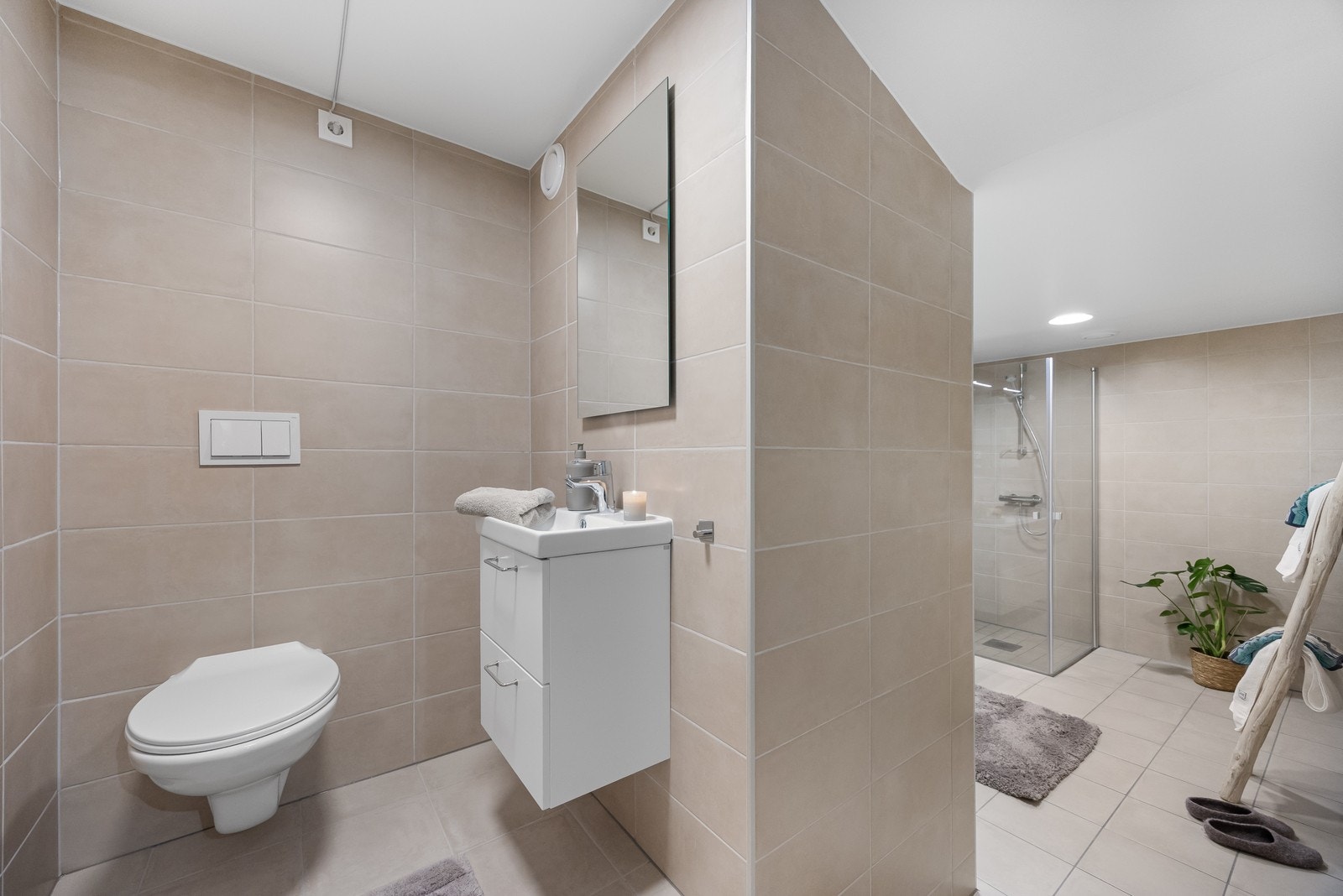Det er laget til en delvis åpen løsning mot WC, men er likevel praktisk skjult mot resten av badet. Galleribilde