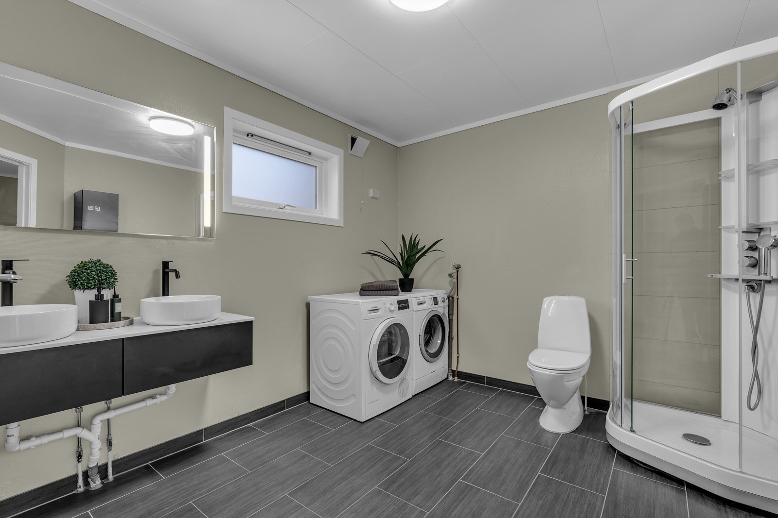 Badet i leiligheten har en flott, nyere baderomsinnredning som inkluderer to frittstående servanter Galleribilde