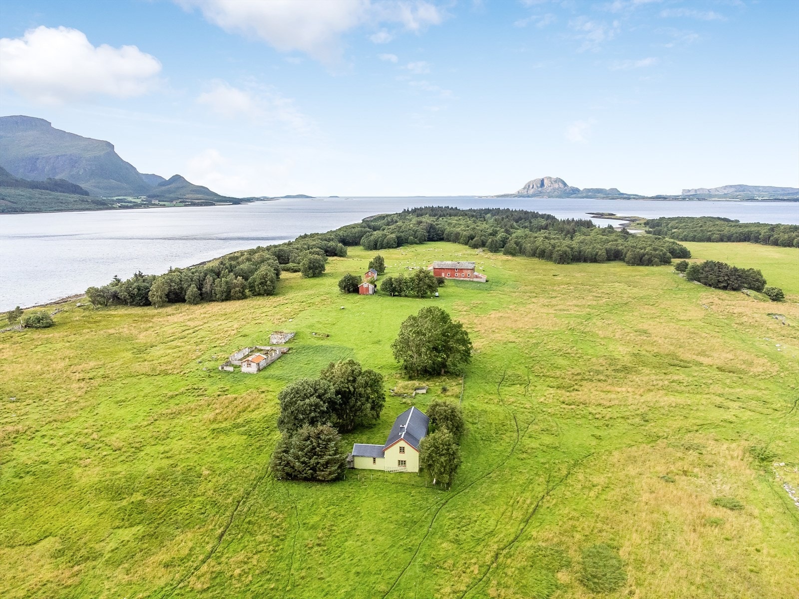 Tomt på 1.403 m² som er inngjerdet og opparbeidet med plen, busker og trær. Her ser du Torghatten i sør. Galleribilde
