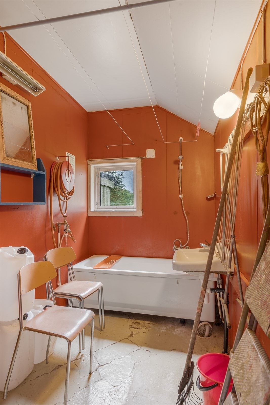 Fra kjøkkenet er det inngang til tilbygd del i sørøst som inneholder gang, verksted/bod og bad. Bad med støpt gulv og malte plater på vegger. Galleribilde