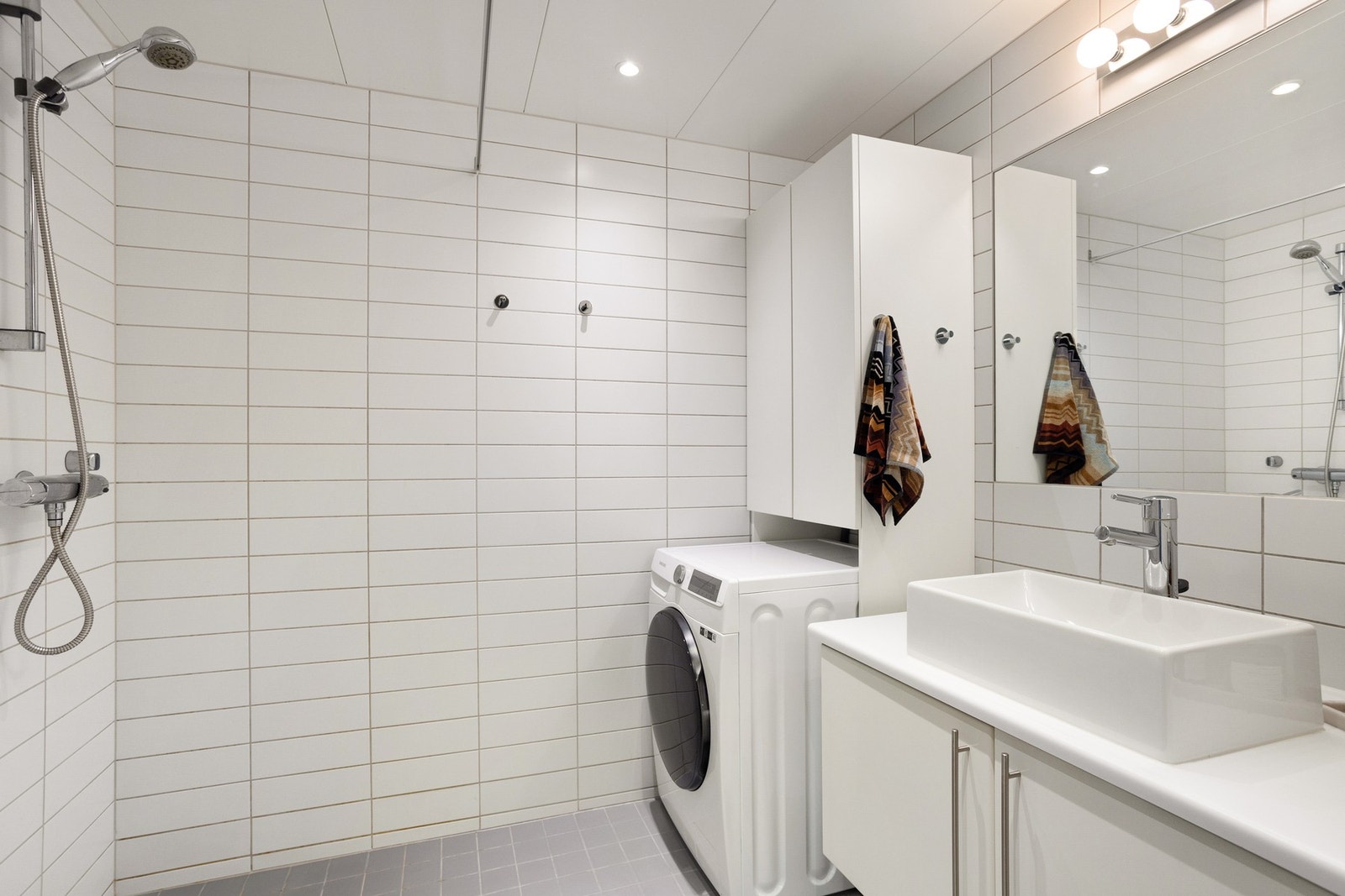 Lyst, flislagt baderom med varme i gulv og downlights i himling. Galleribilde