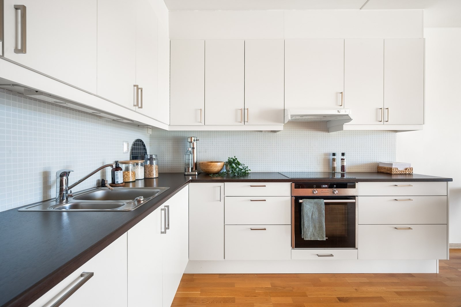 Kjøkkenet er velutstyrt med integrerte hvitevarer som koketopp, stekeovn, oppvaskmaskin og kombinert kjøle- og fryseskap. Galleribilde