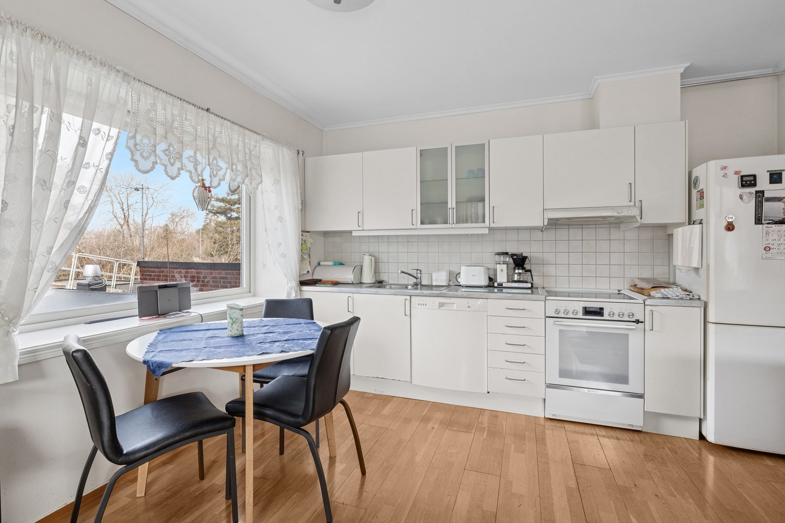 Kjøkken med hvite glatte fronter, og laminat benkeplate. Galleribilde