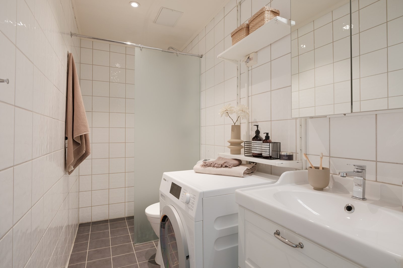 Pent og tidløst bad med dusj, servant med underskap, toalett og speilskap. Plass/opplegg til vaskemaskin. Galleribilde