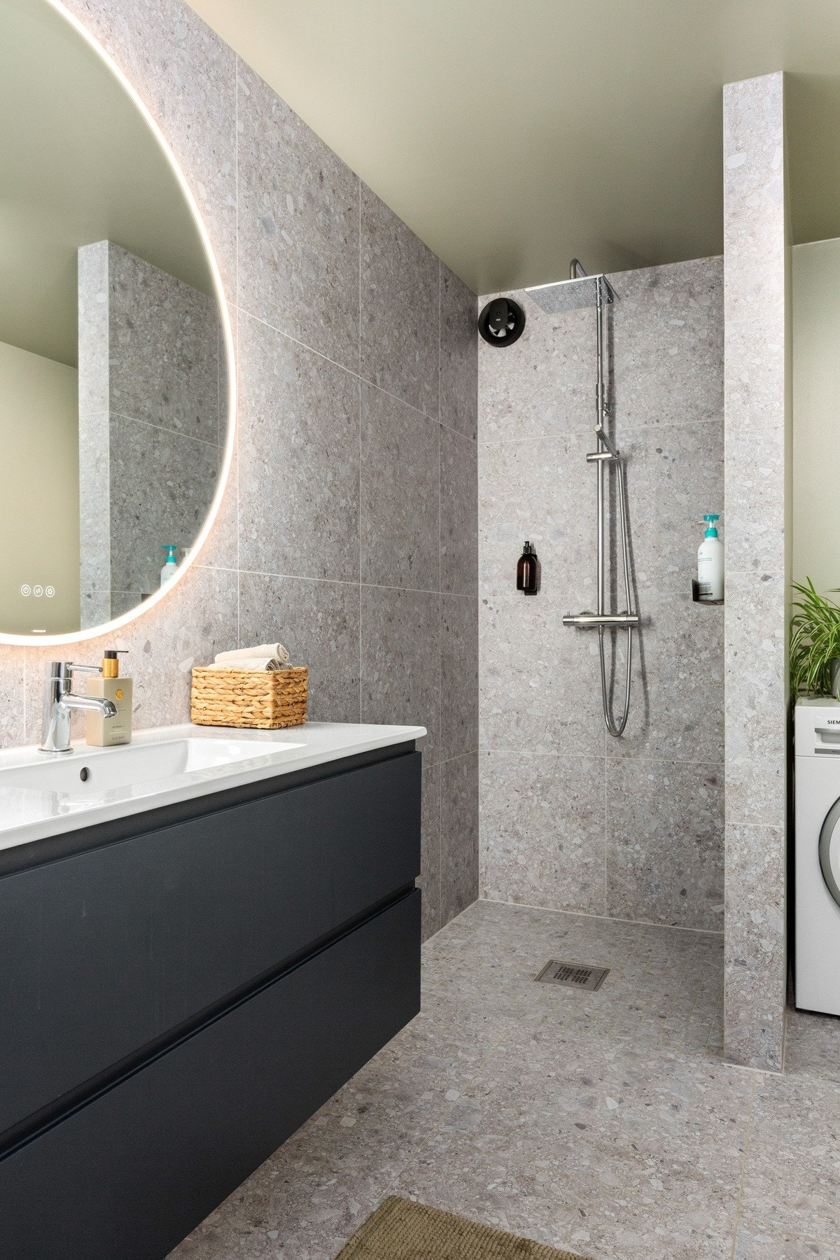 Badet er innredet med nedfelt servant, veggmontert toalett, dusjhjørne og opplegg for vaskemaskin. Galleribilde