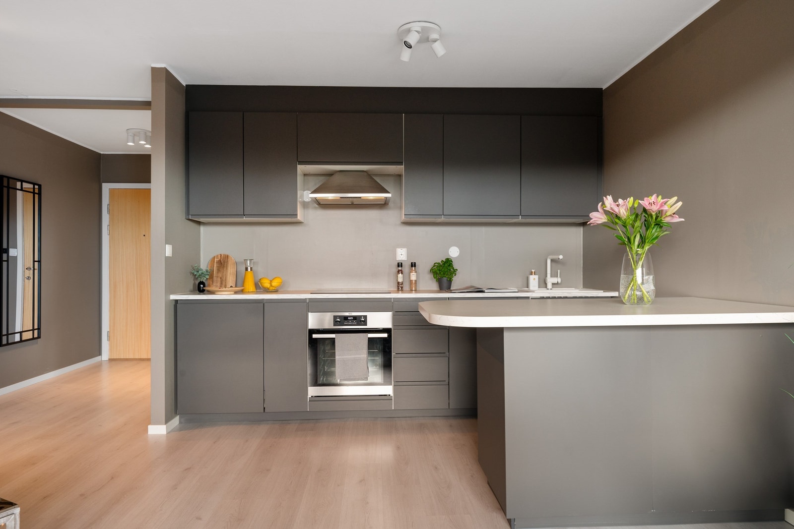 Stilrent designet kjøkken med glatte fronter og kjøkkenøy, med integrerte hvitevarer fra 2020 Galleribilde